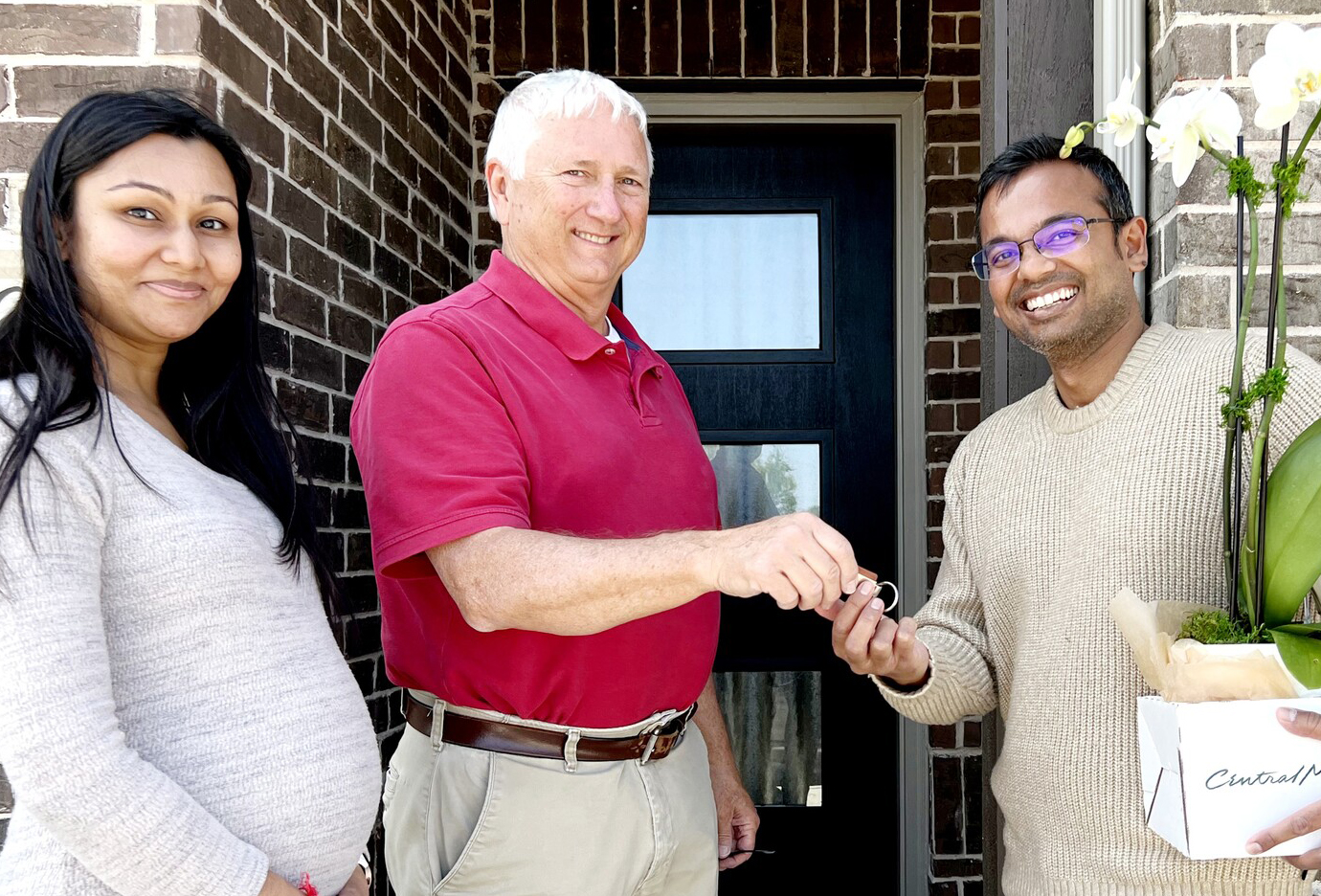 Beazer employee handing homeowners key to their new home