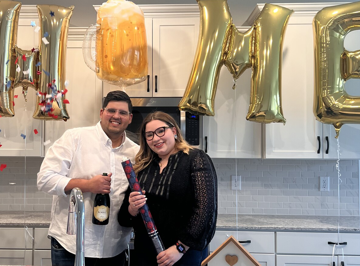 Couple in kitchen with home balloons over their heads