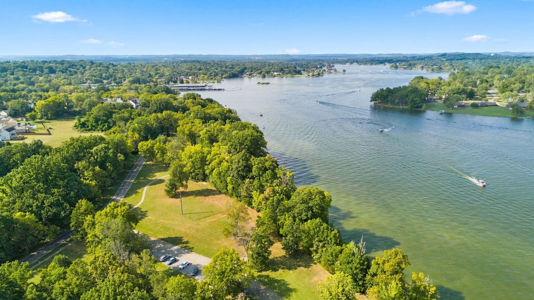 Old Hickory Lake with trees and houses lining the water and two boats riding on the lake