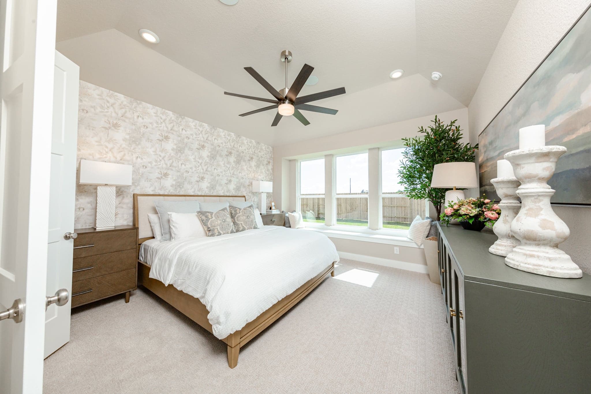 primary bedroom with tall ceilings and windows