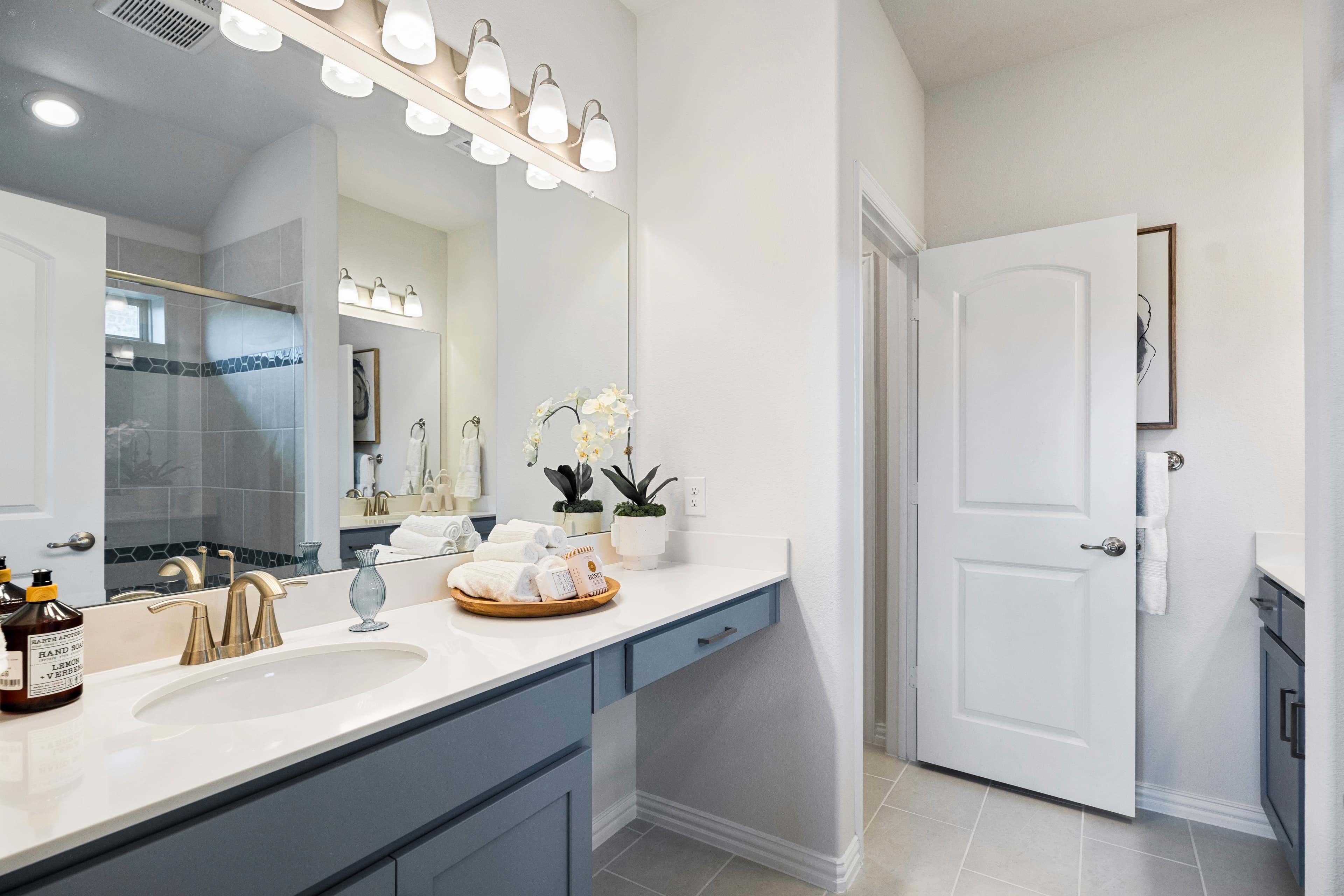primary bathroom with two sinks and tile floors