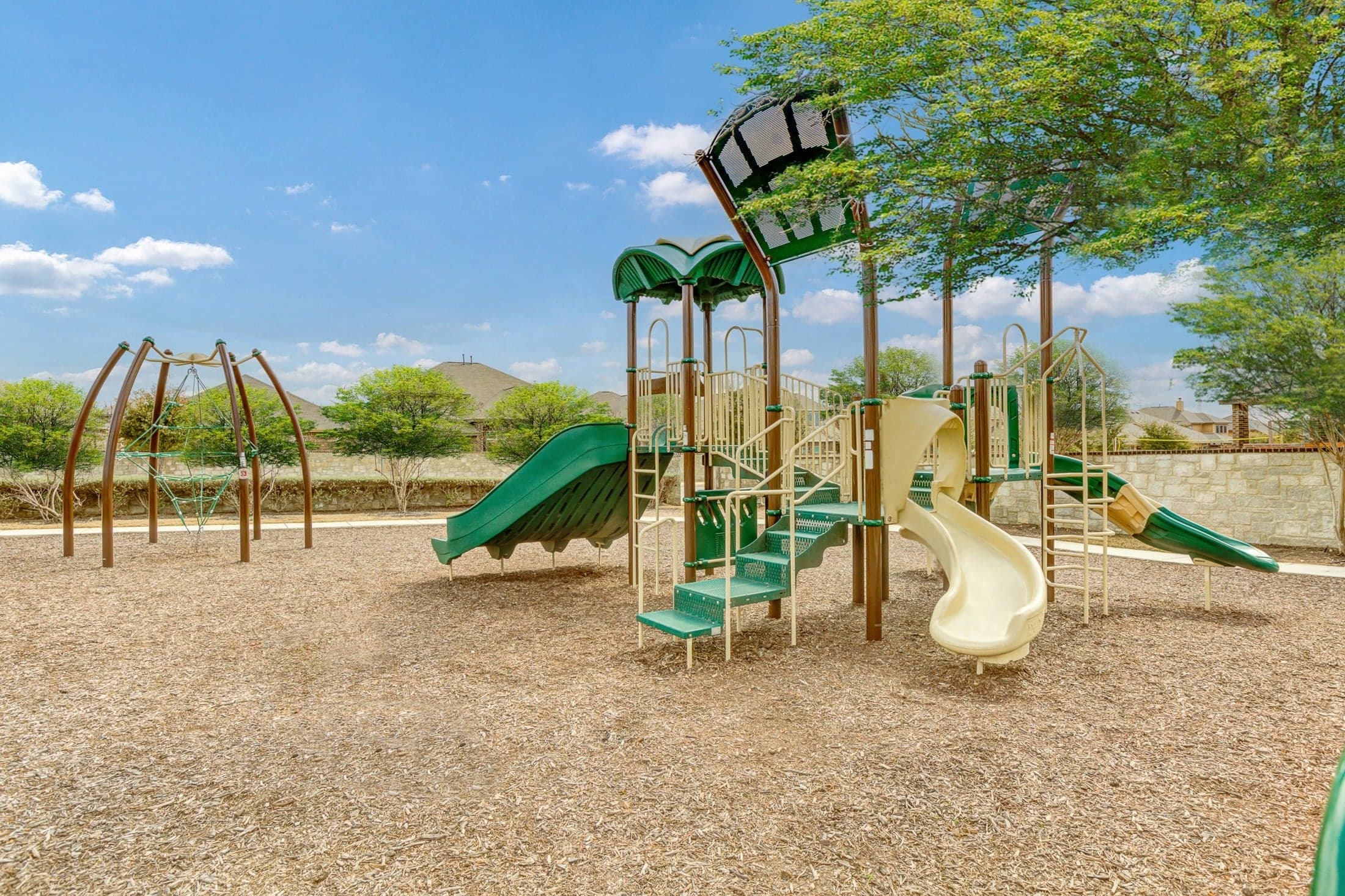 playground with slides, tree, and play area 