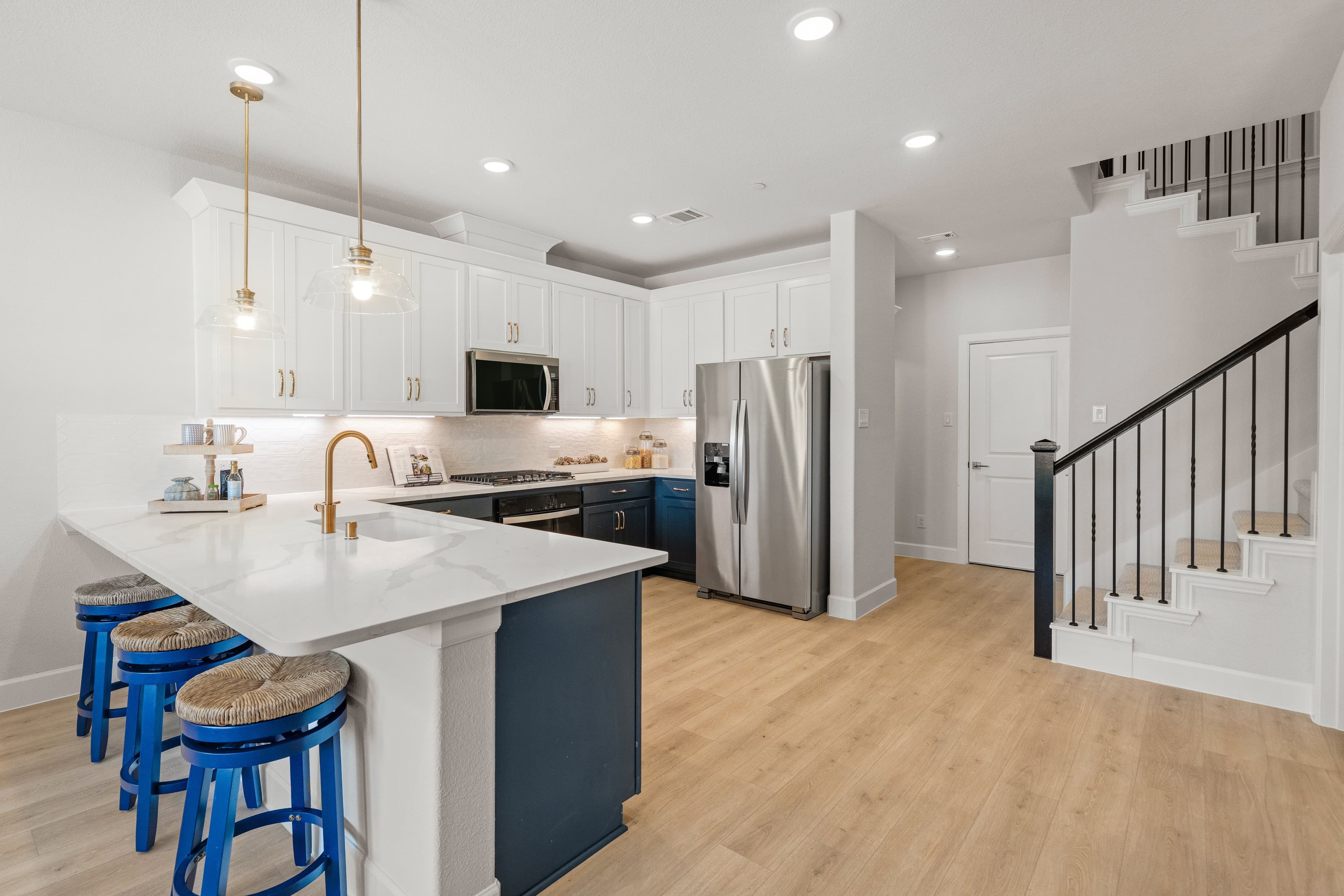 open kitchen with wood floors and white cabinets