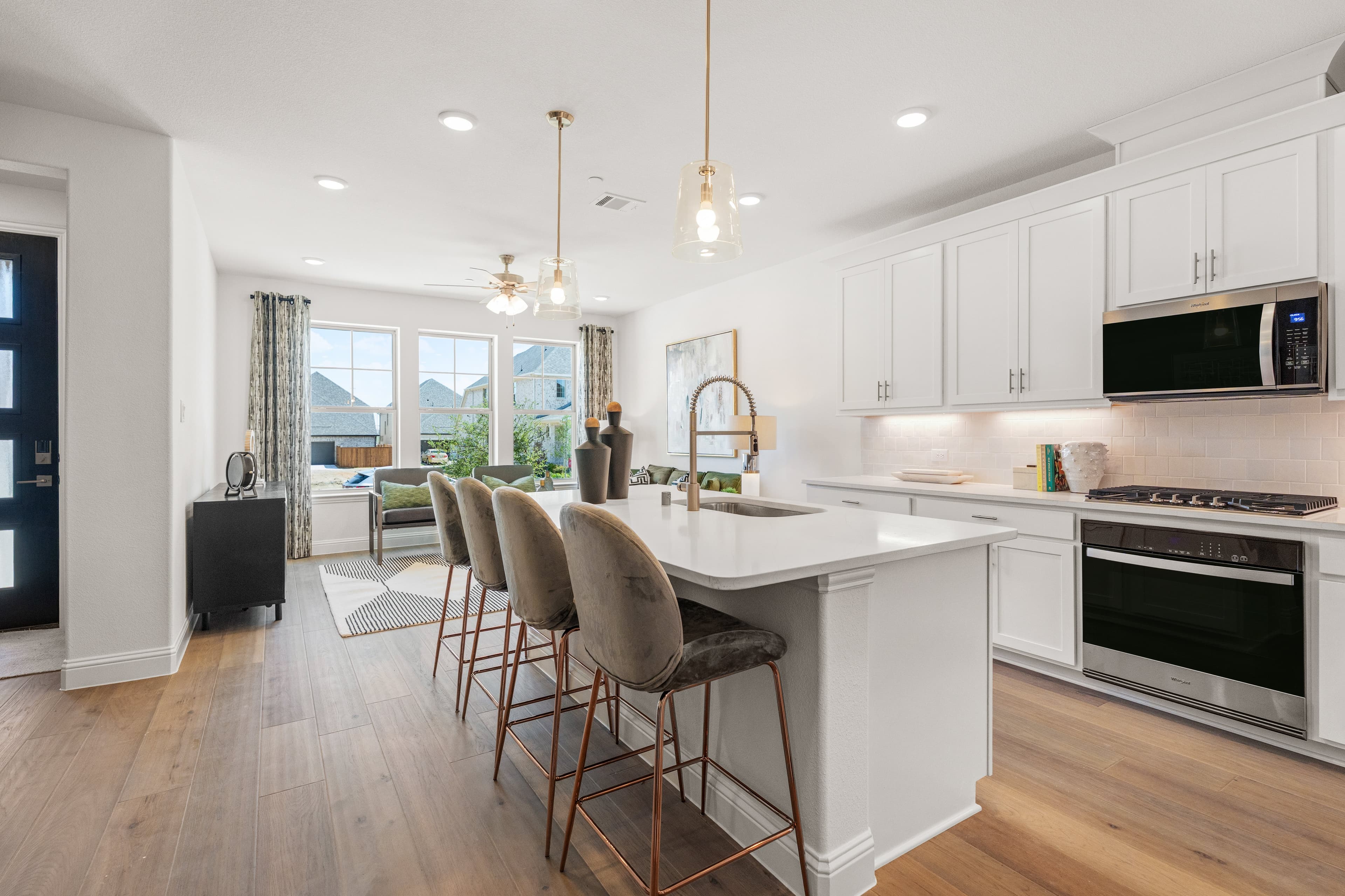 open kitchen with wood floors and white cabinets