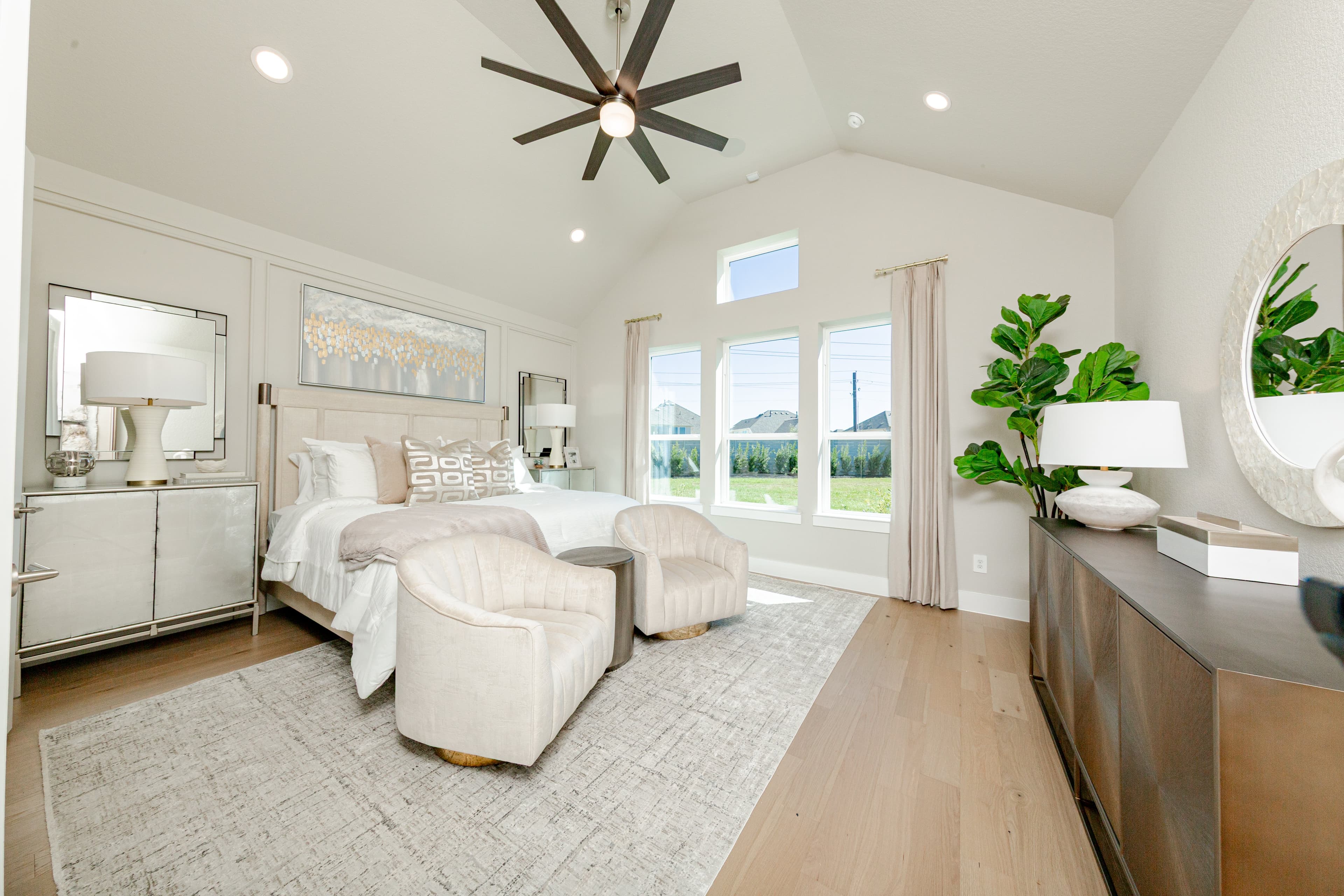 primary bedroom with vaulted ceiling and hardwood flooring