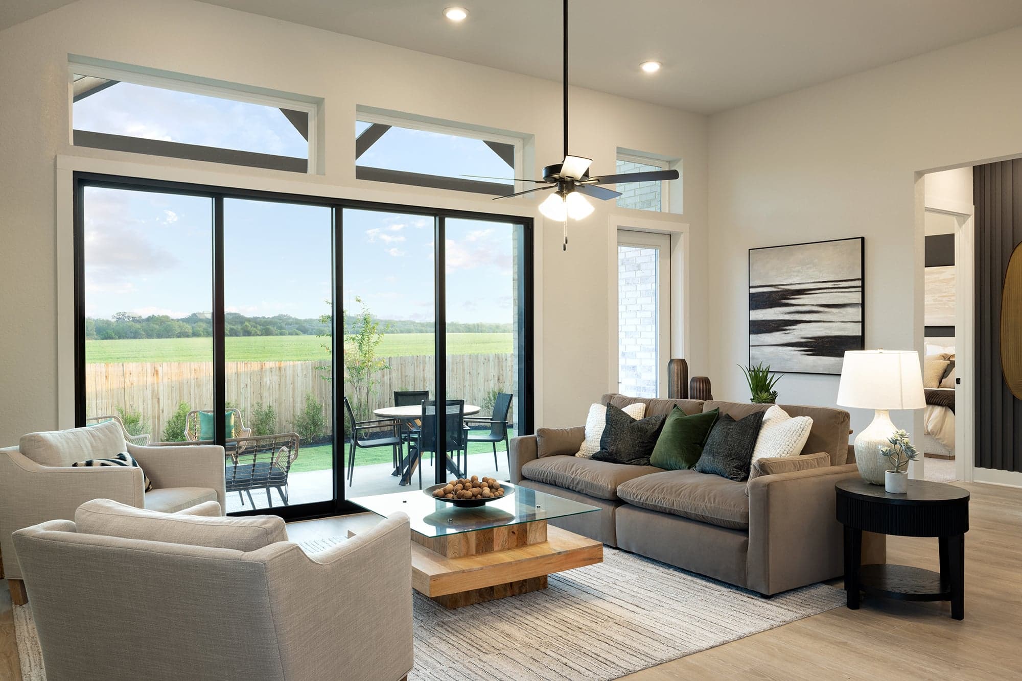 great room with brown flooring, sliding glass door & a ceiling fan