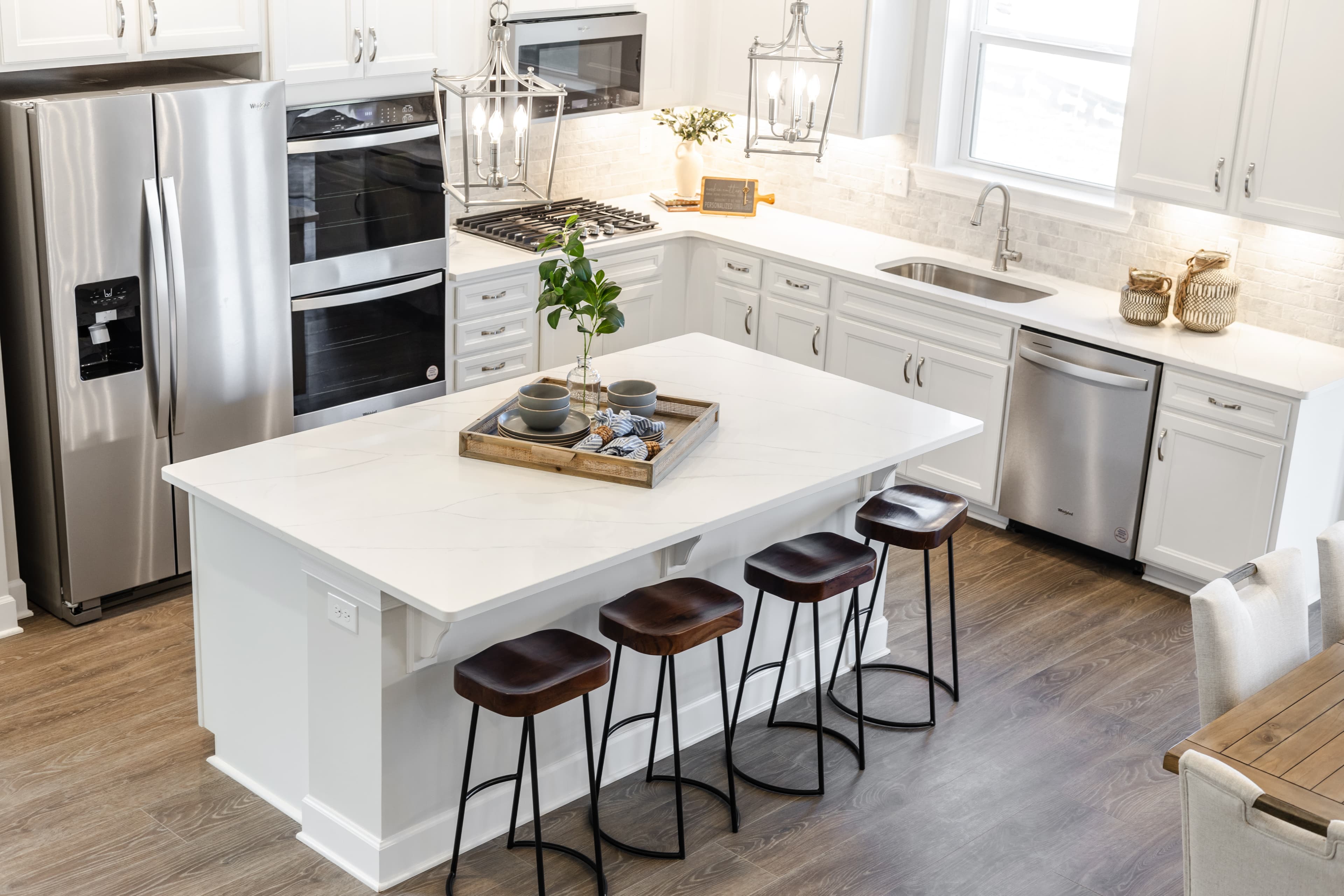 kitchen with white countertops, white cabinets, stainless steel appliances and hardwood floors