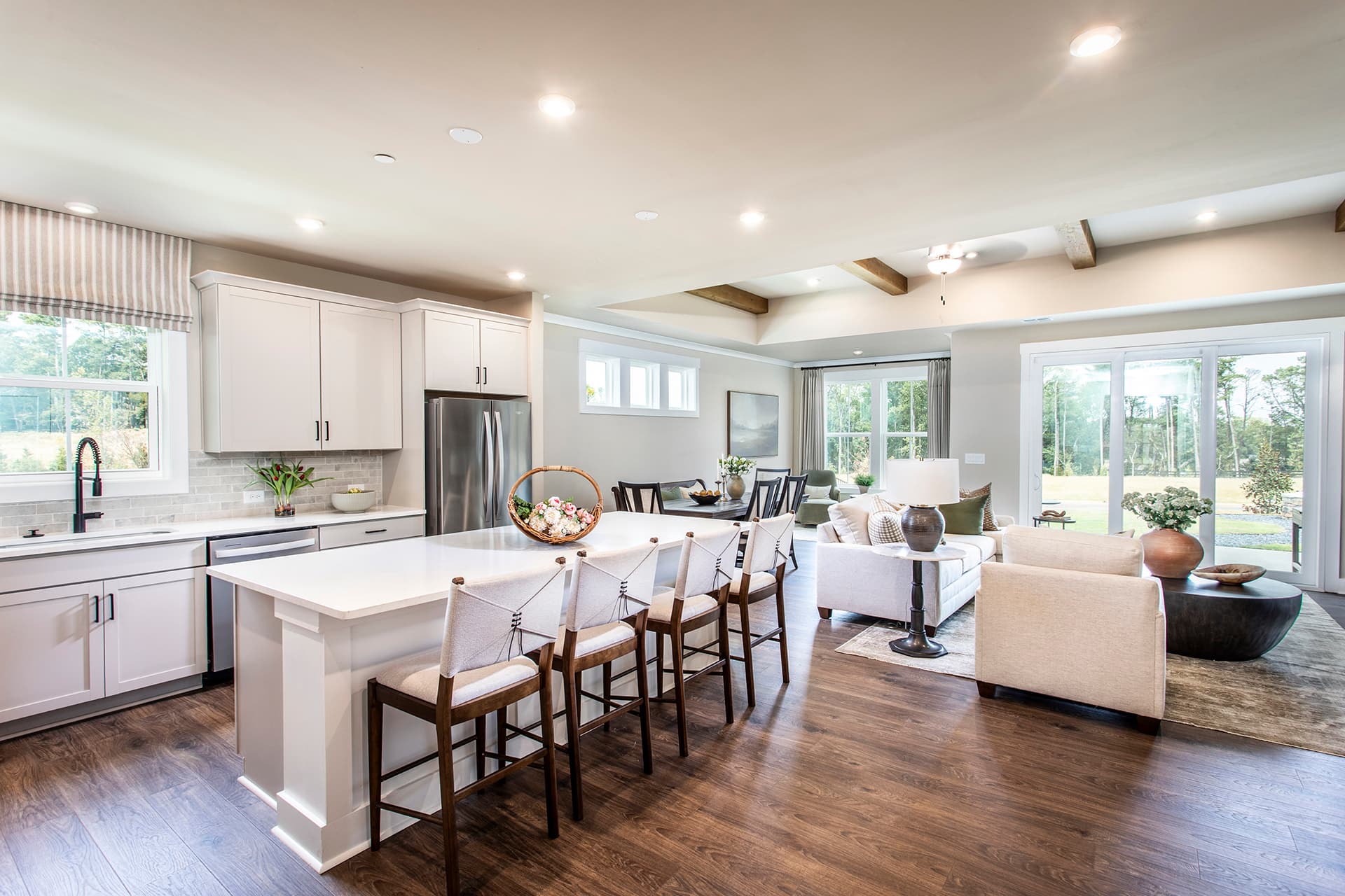 kitchen, great room, and dining room with hard surface flooring and decor