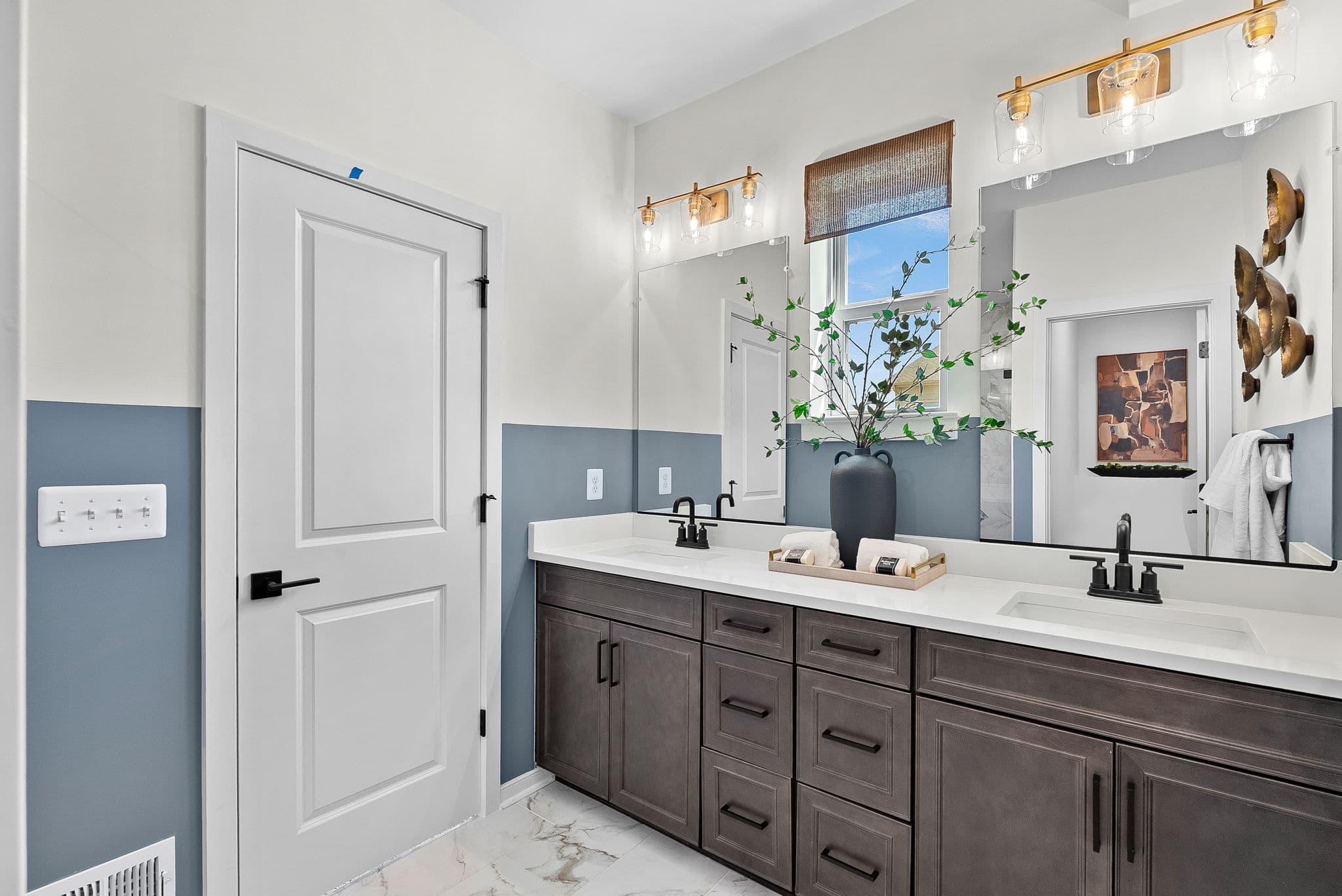 primary bathroom with two sinks and brown cabinets