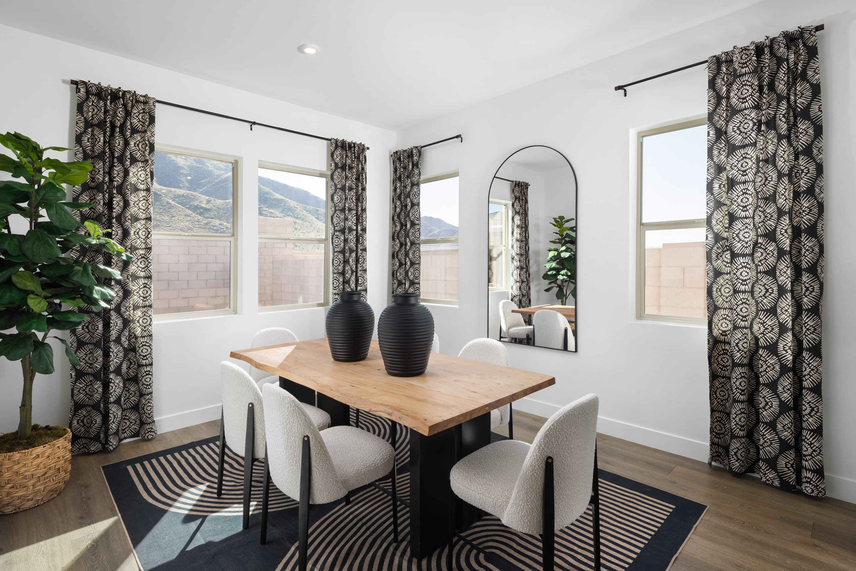 spacious dining room with a wooden dining table, white dining chairs, and windows for natural light 