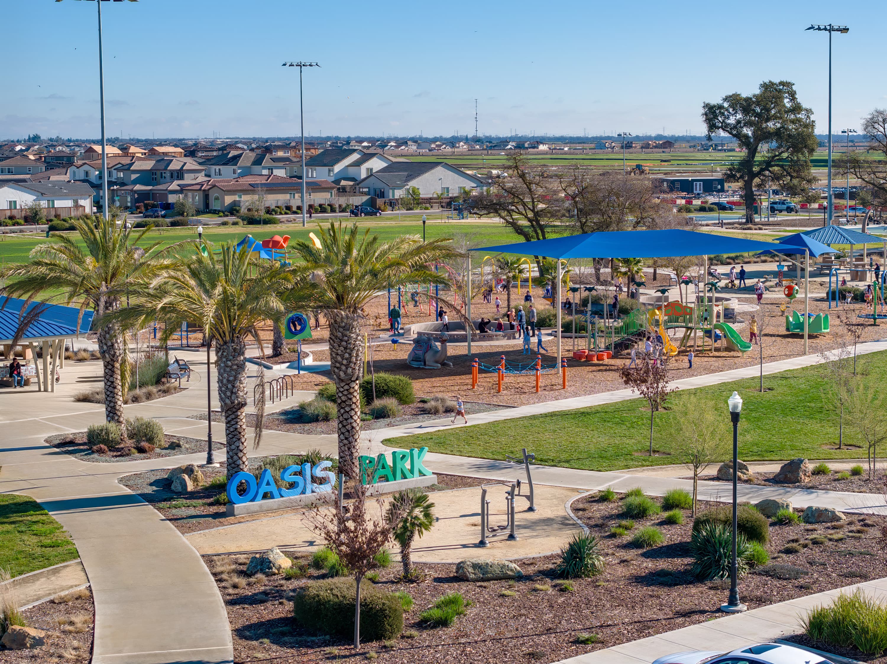 several playgrounds with blue shade structures