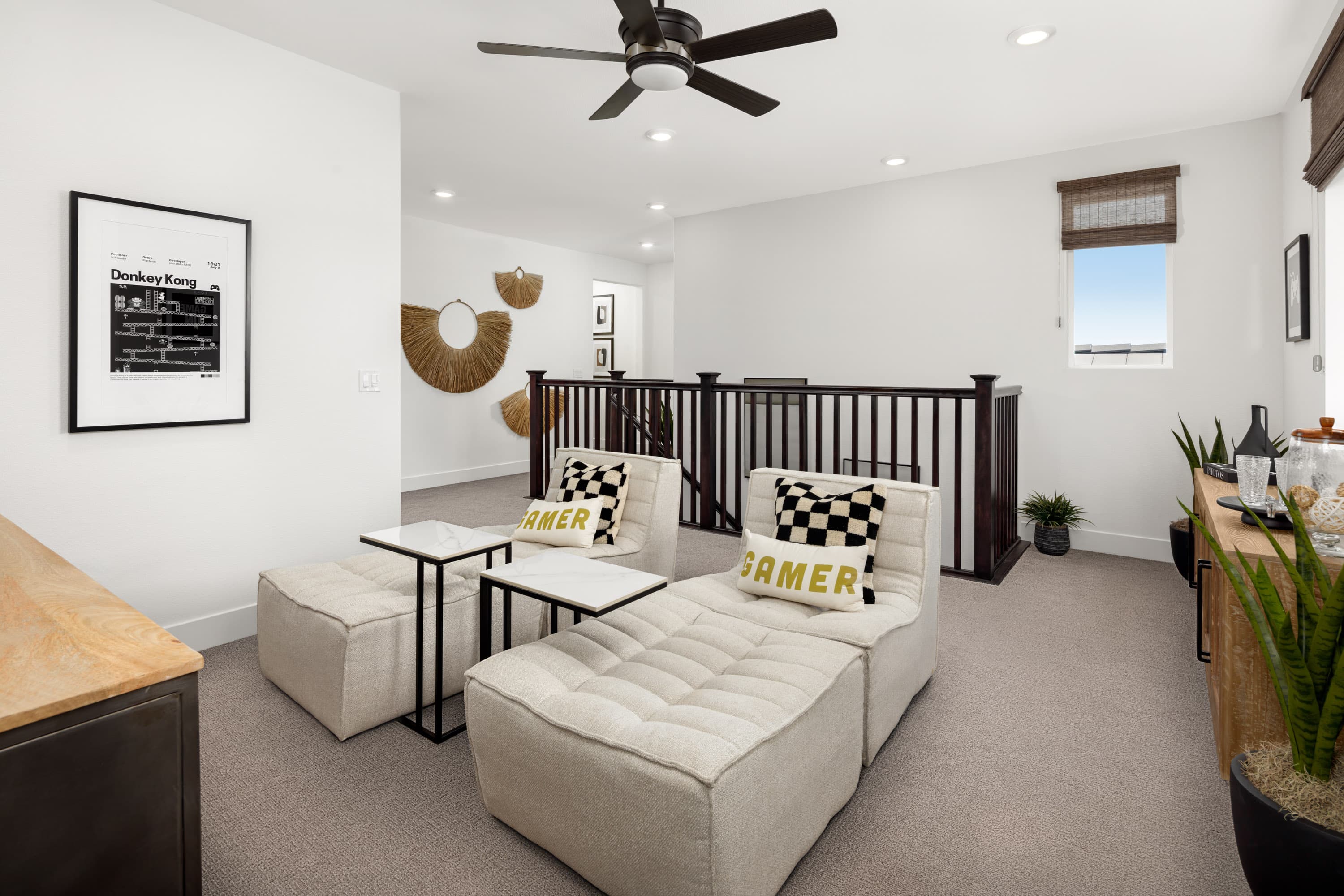 loft with two tan chaises, and black ceiling fan