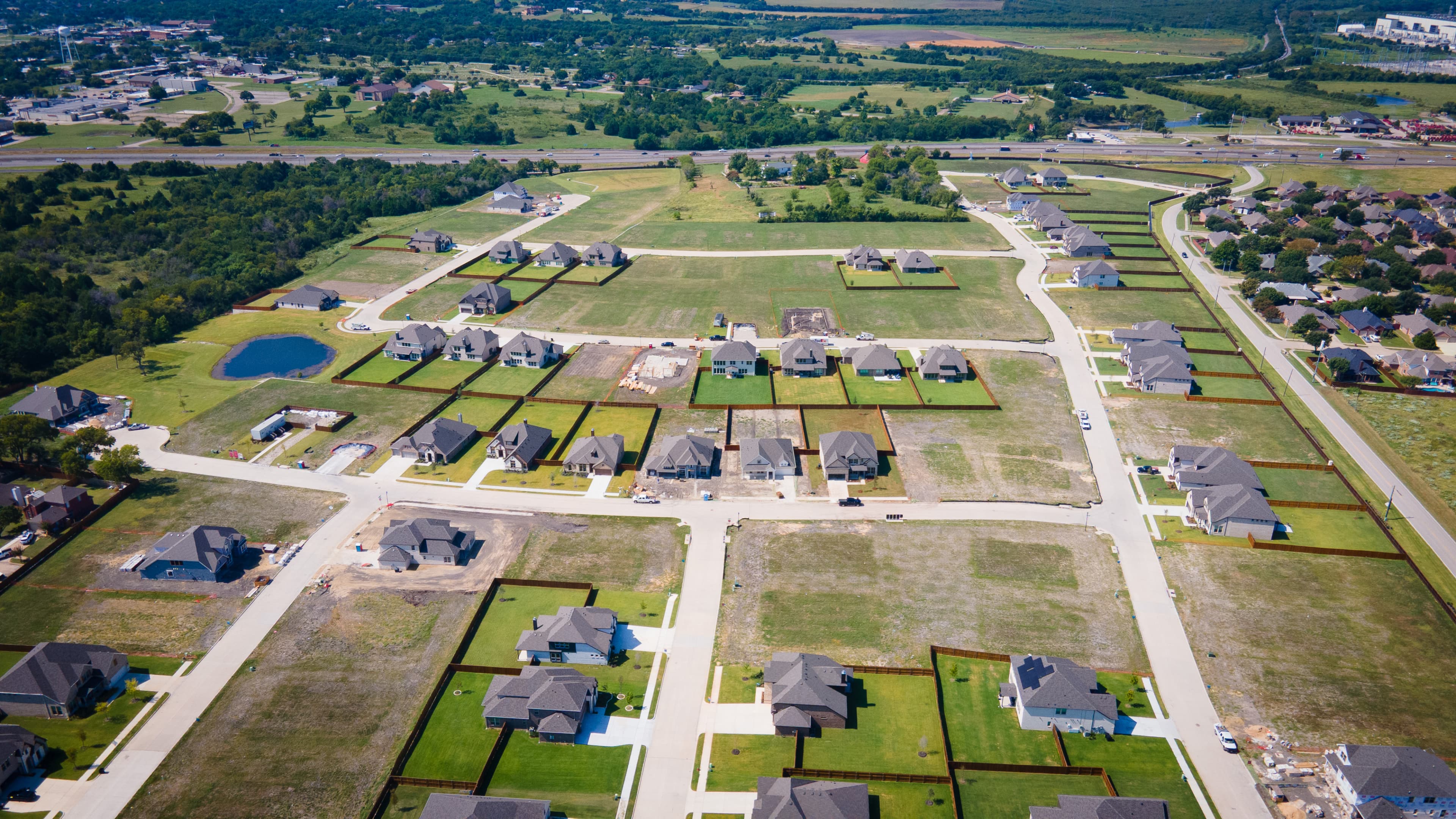 aerial of the community with large homesites and pond 