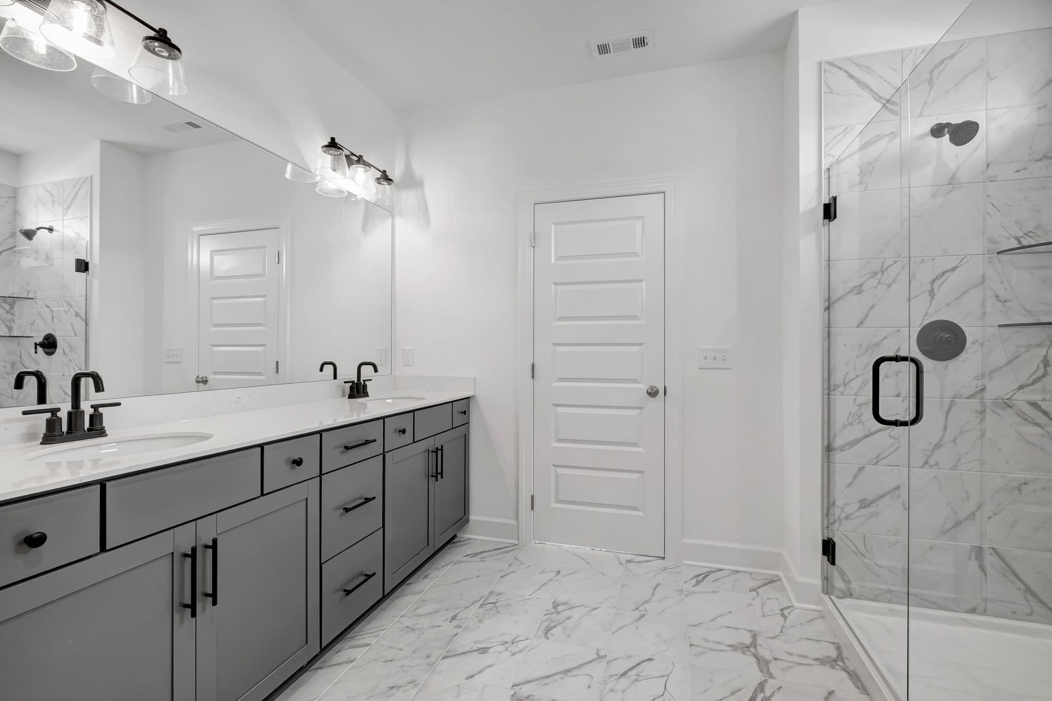 bathroom with marble floors and grey cabinets with double vanity