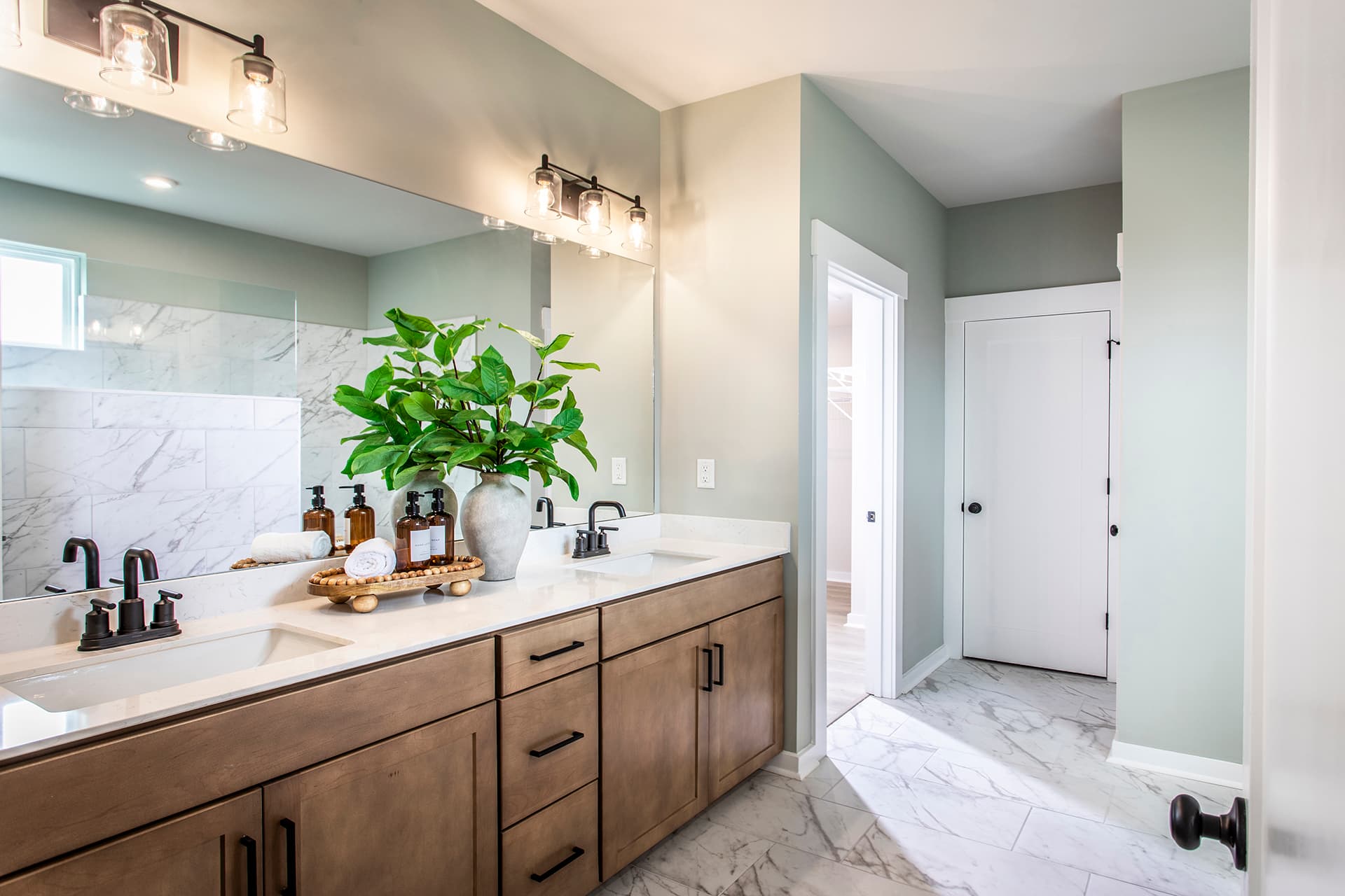 primary bathroom with wood cabinets and tile flooring