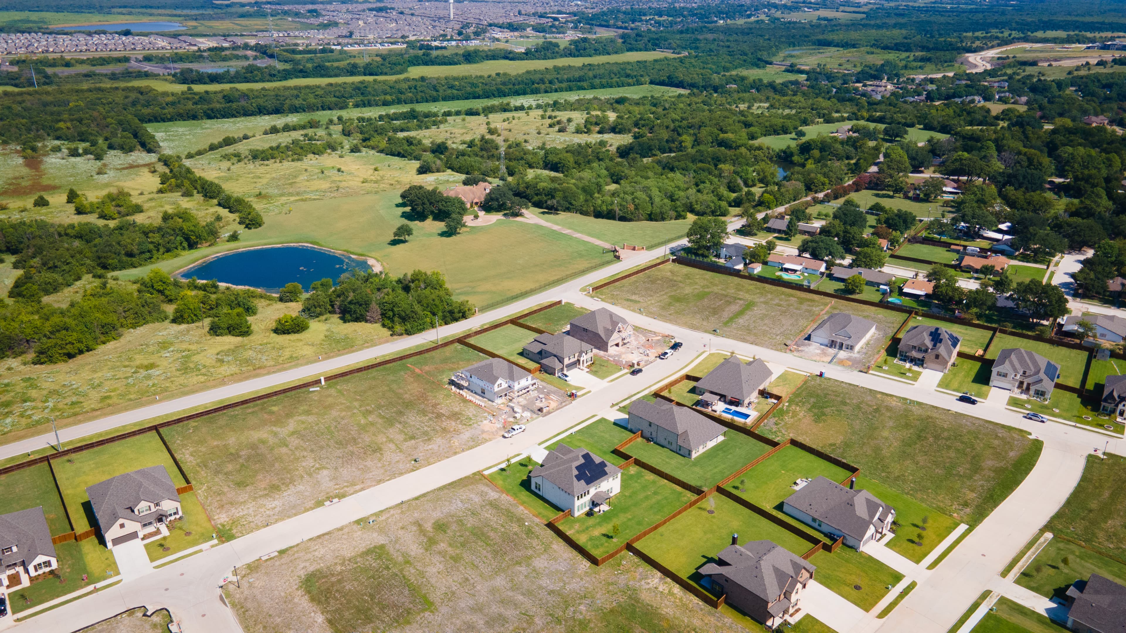 aerial of the community with a pond and green space 