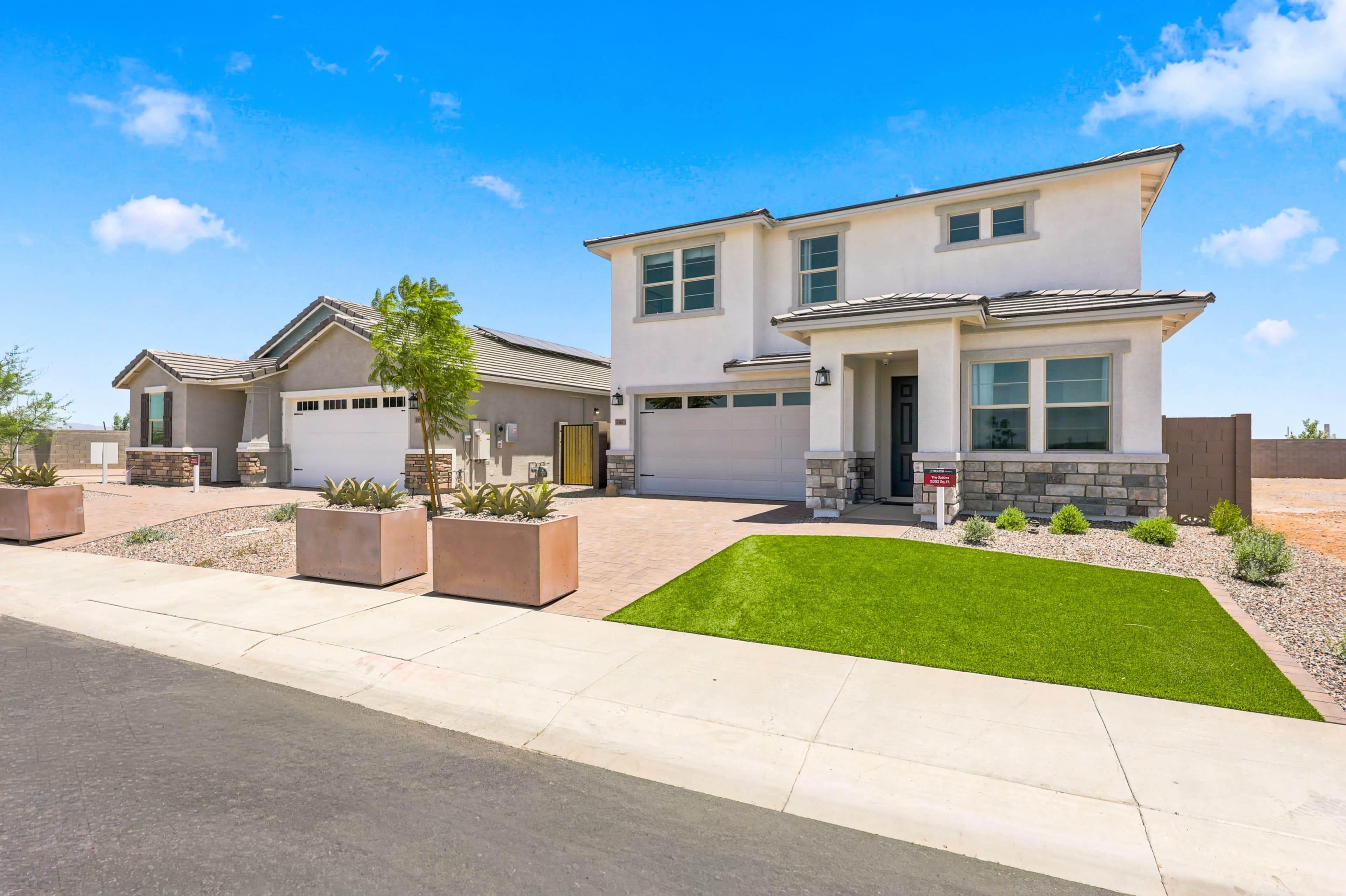 single-story and two-story model homes with desert landscaping
