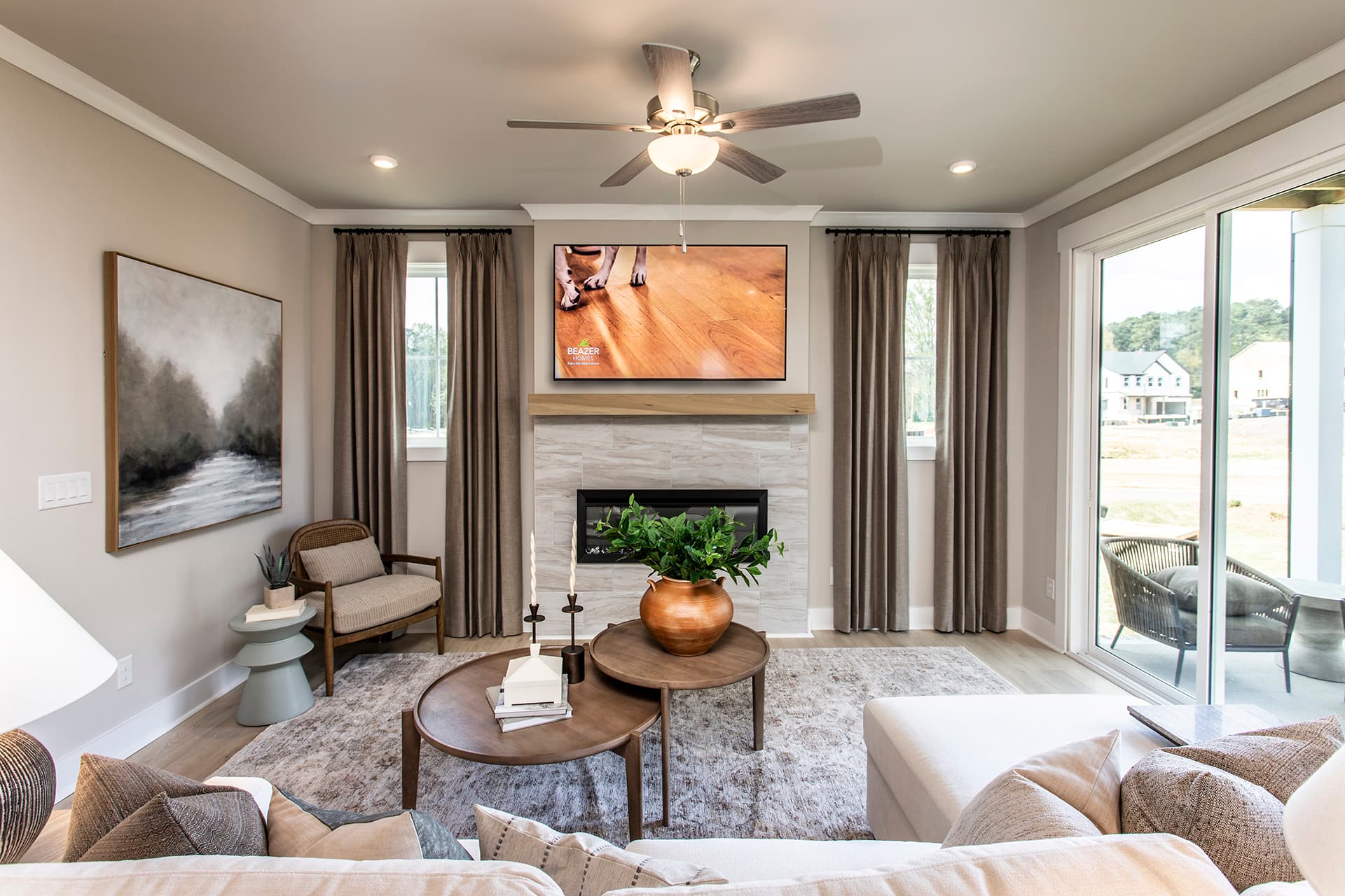 great room with electric fireplace and tri-slide glass doors leading to covered patio
