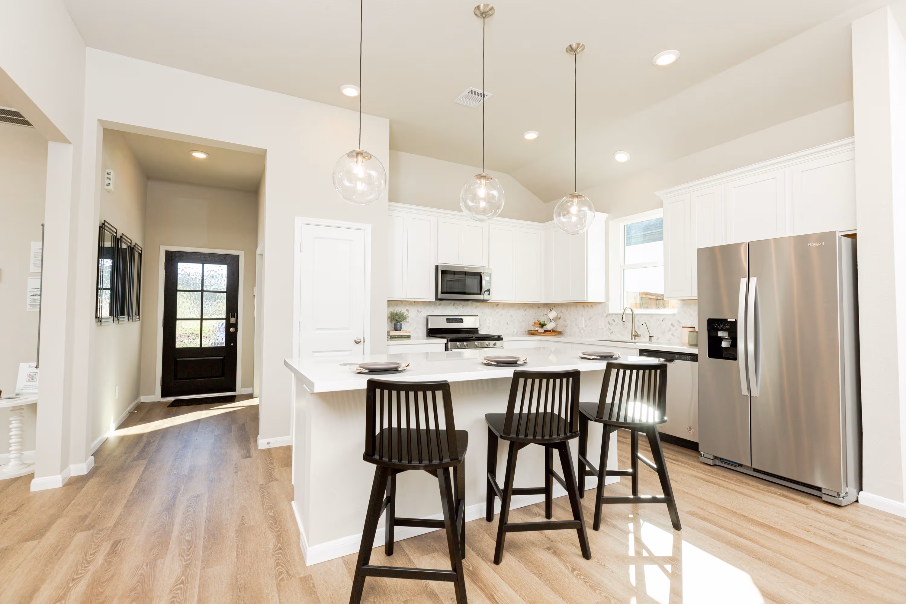 open kitchen with white cabinets and hardwood flooring
