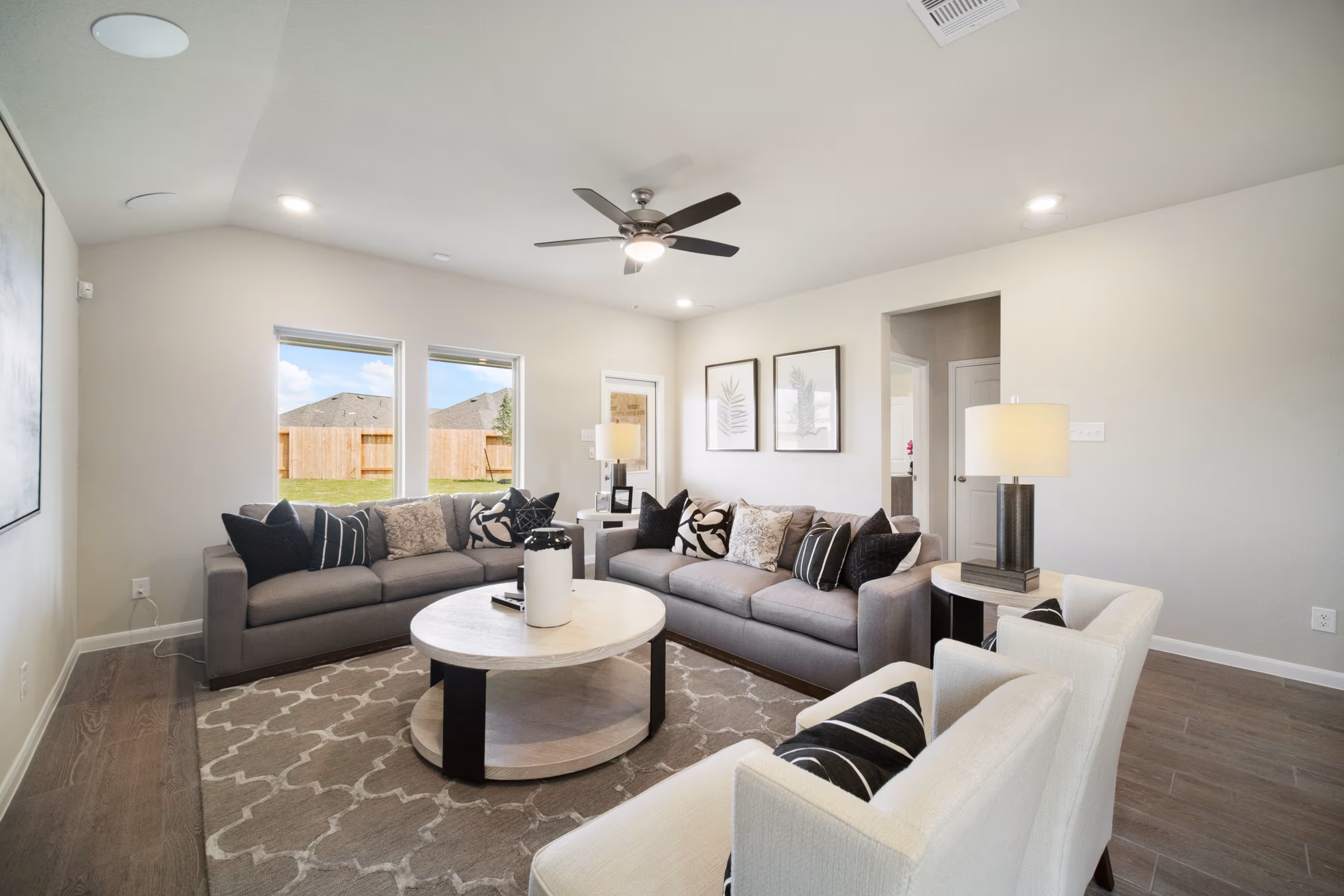 spacious great room with windows and hardwood flooring
