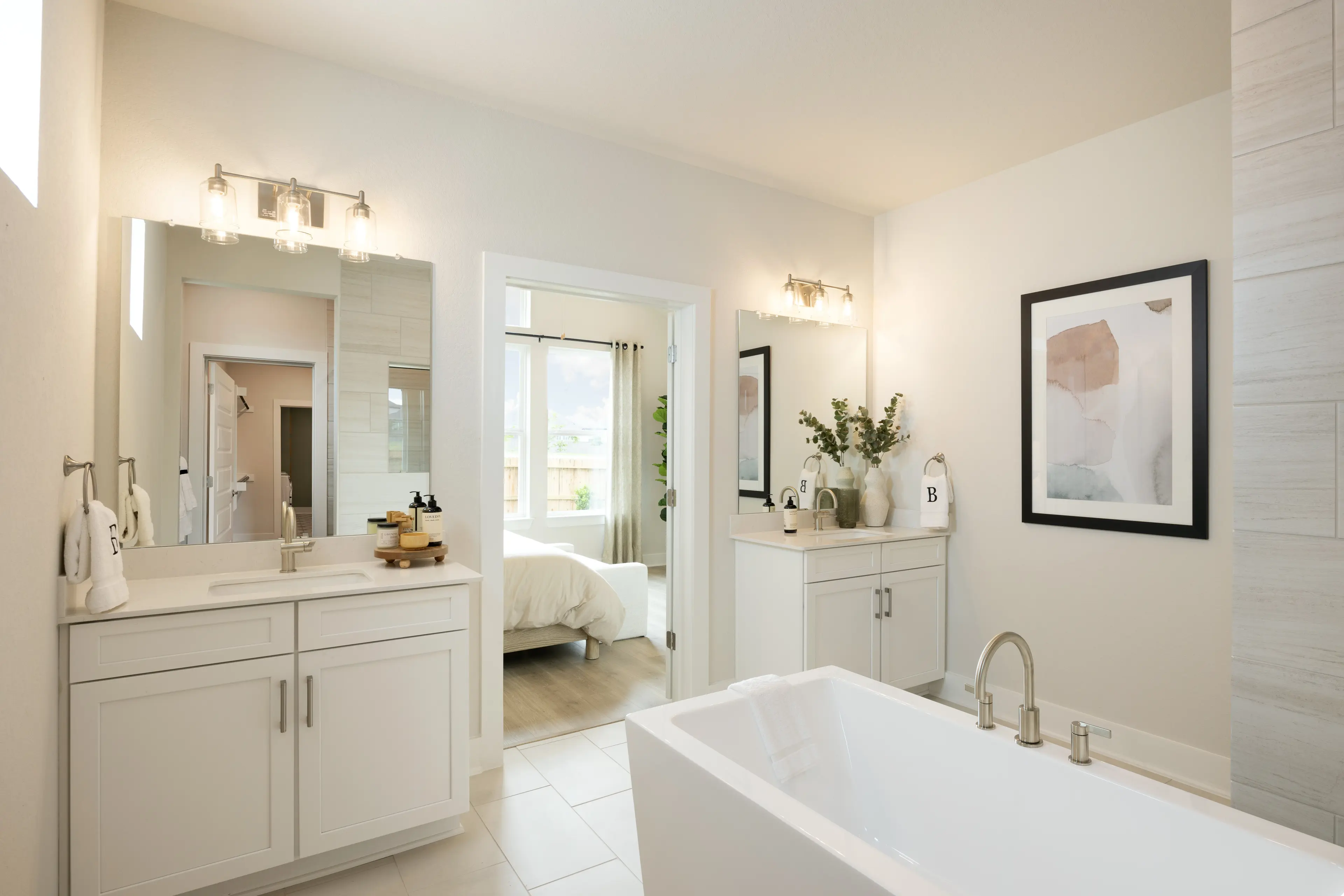 primary bathroom with dual sinks, soaking tub and white flooring