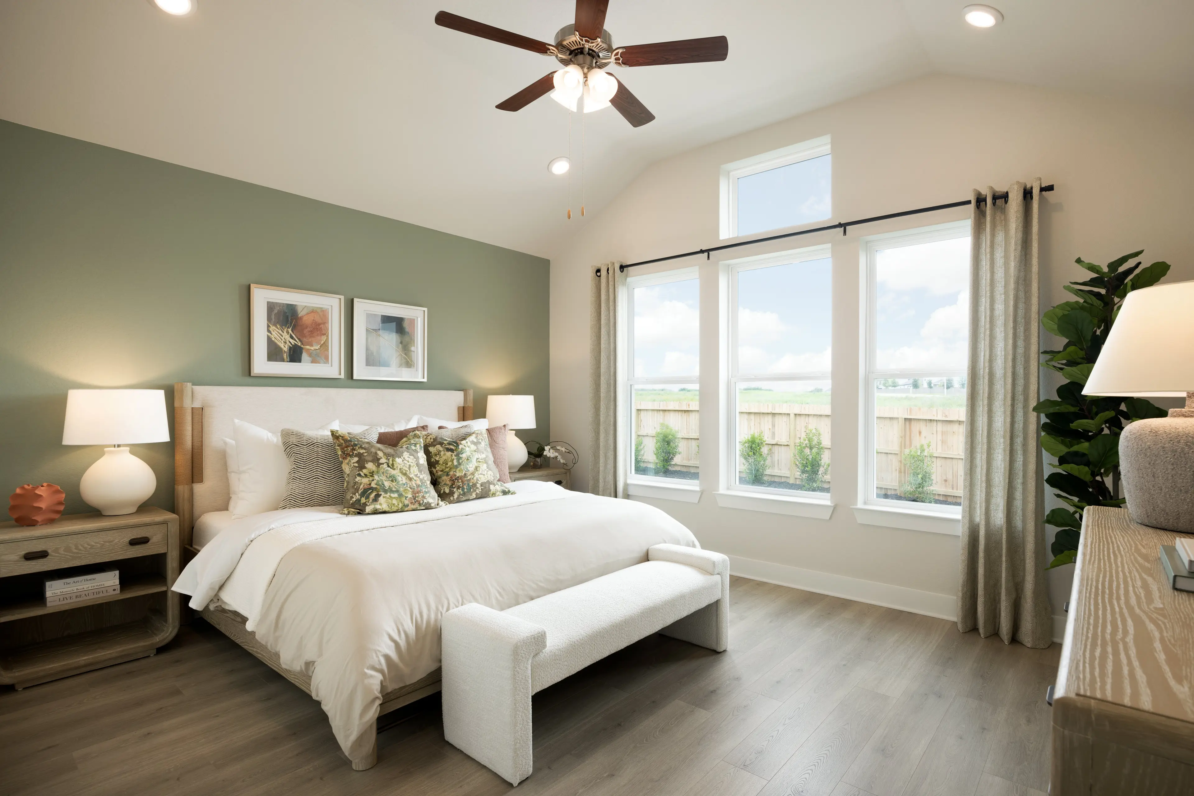 primary bedroom with brown flooring, windows and ceiling fan