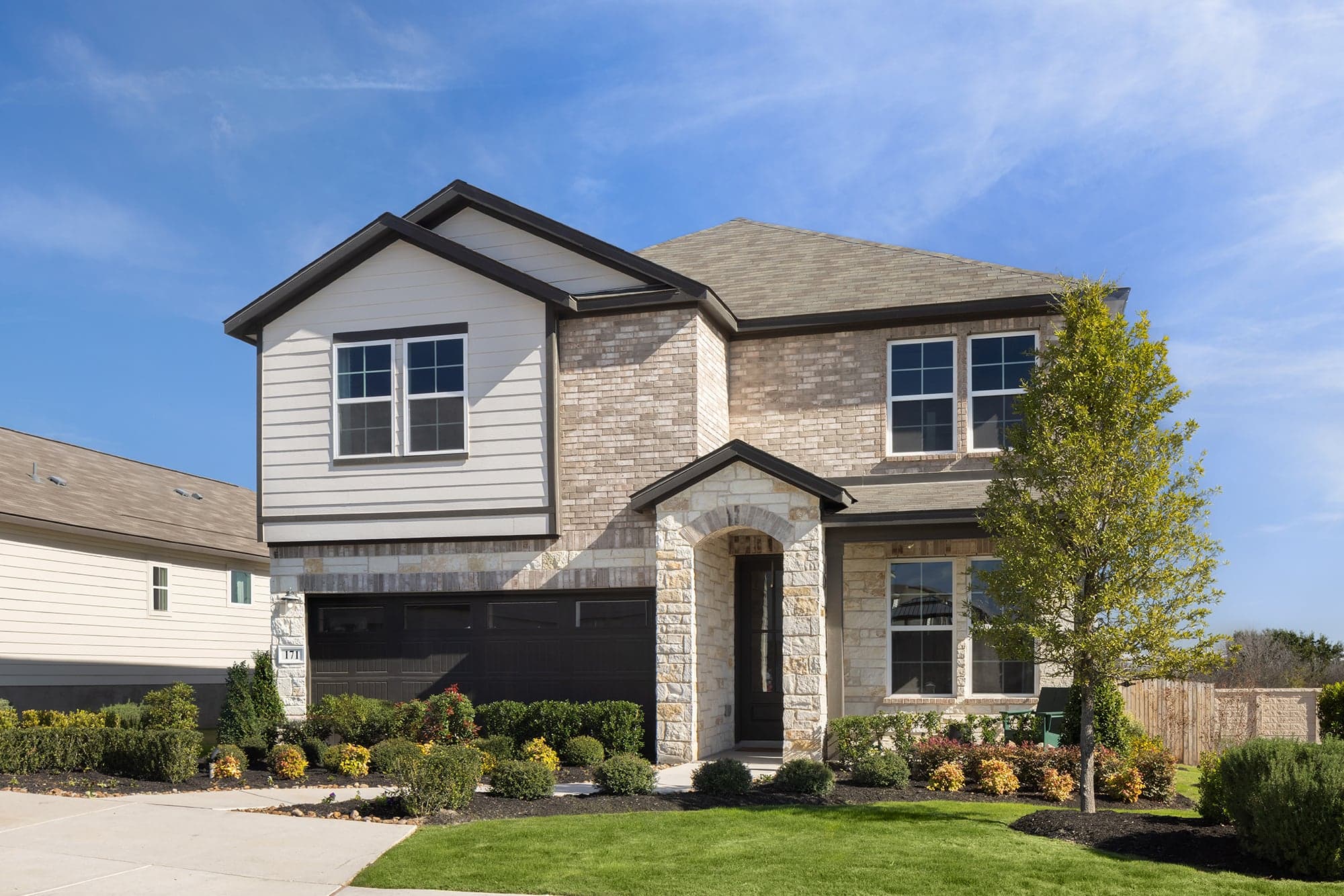 exterior with brick, tree & a 2-car garage