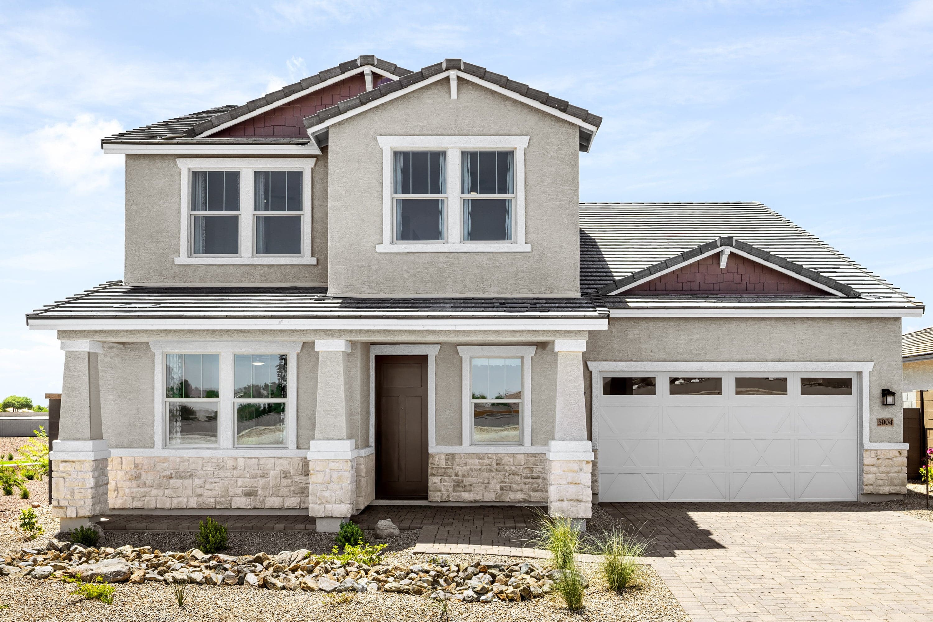 two-story home with desert lanscaping and paver driveway
