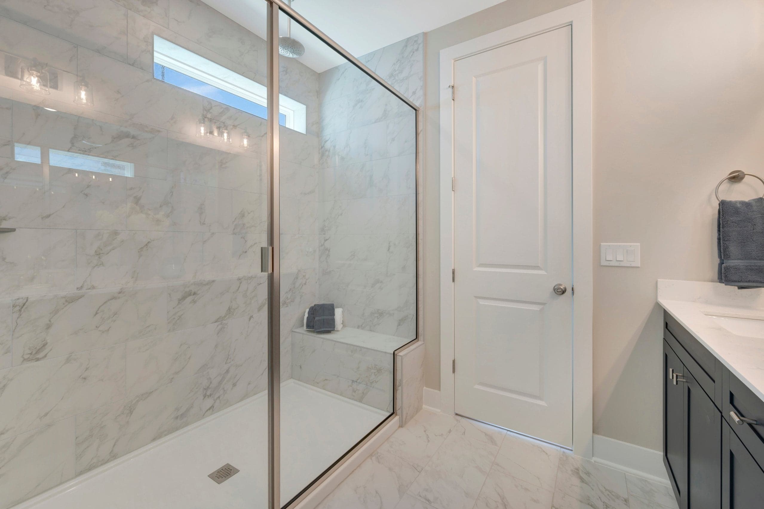 primary bath with a walk-in shower with a window and a bench