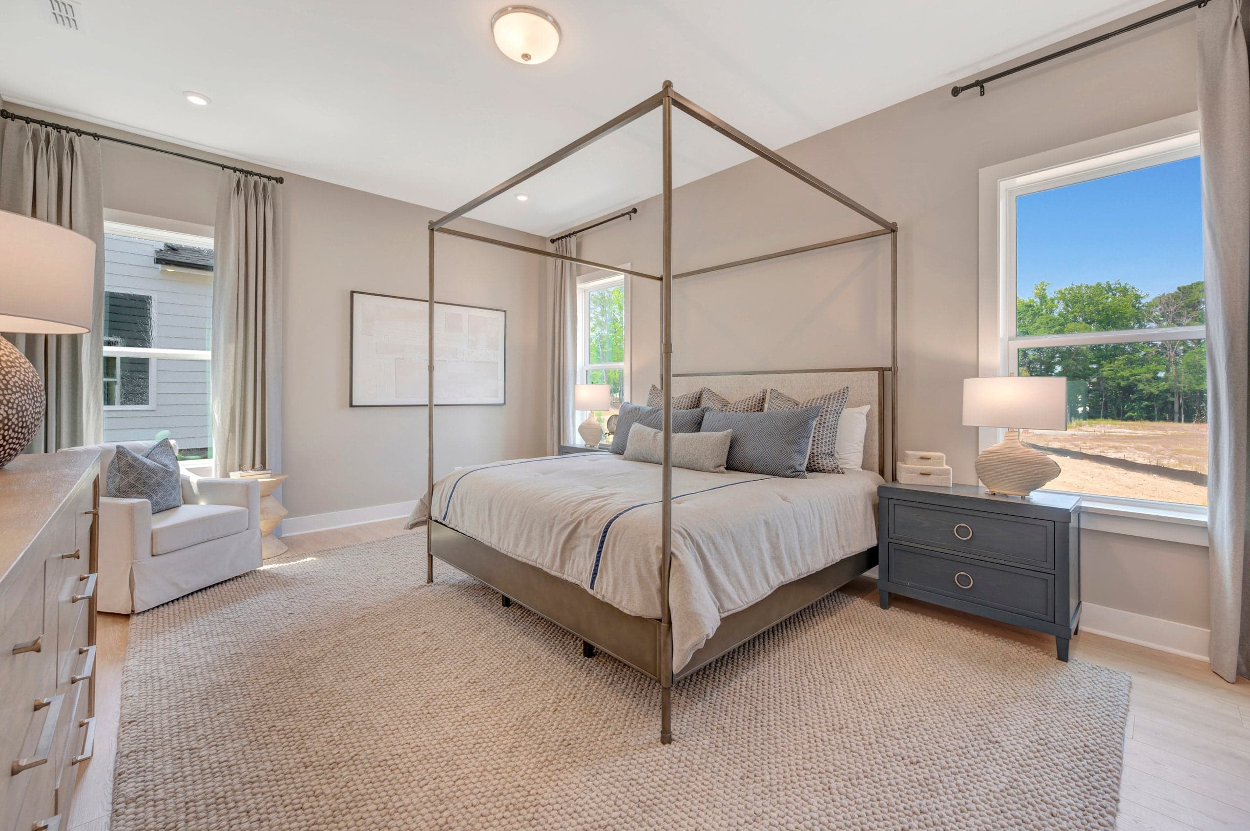primary bedroom with three windows and a rug