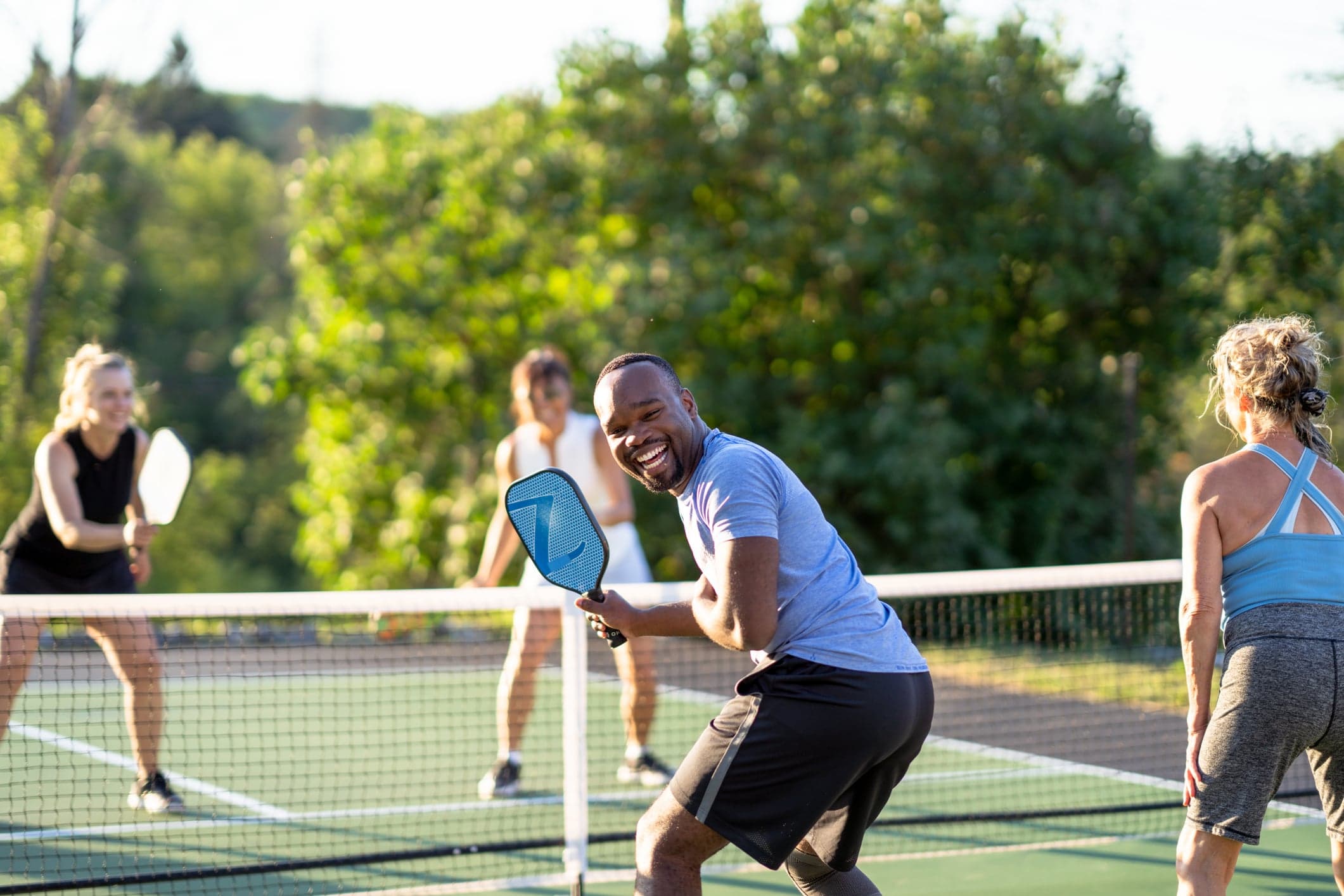 4 people playing pickleball on court