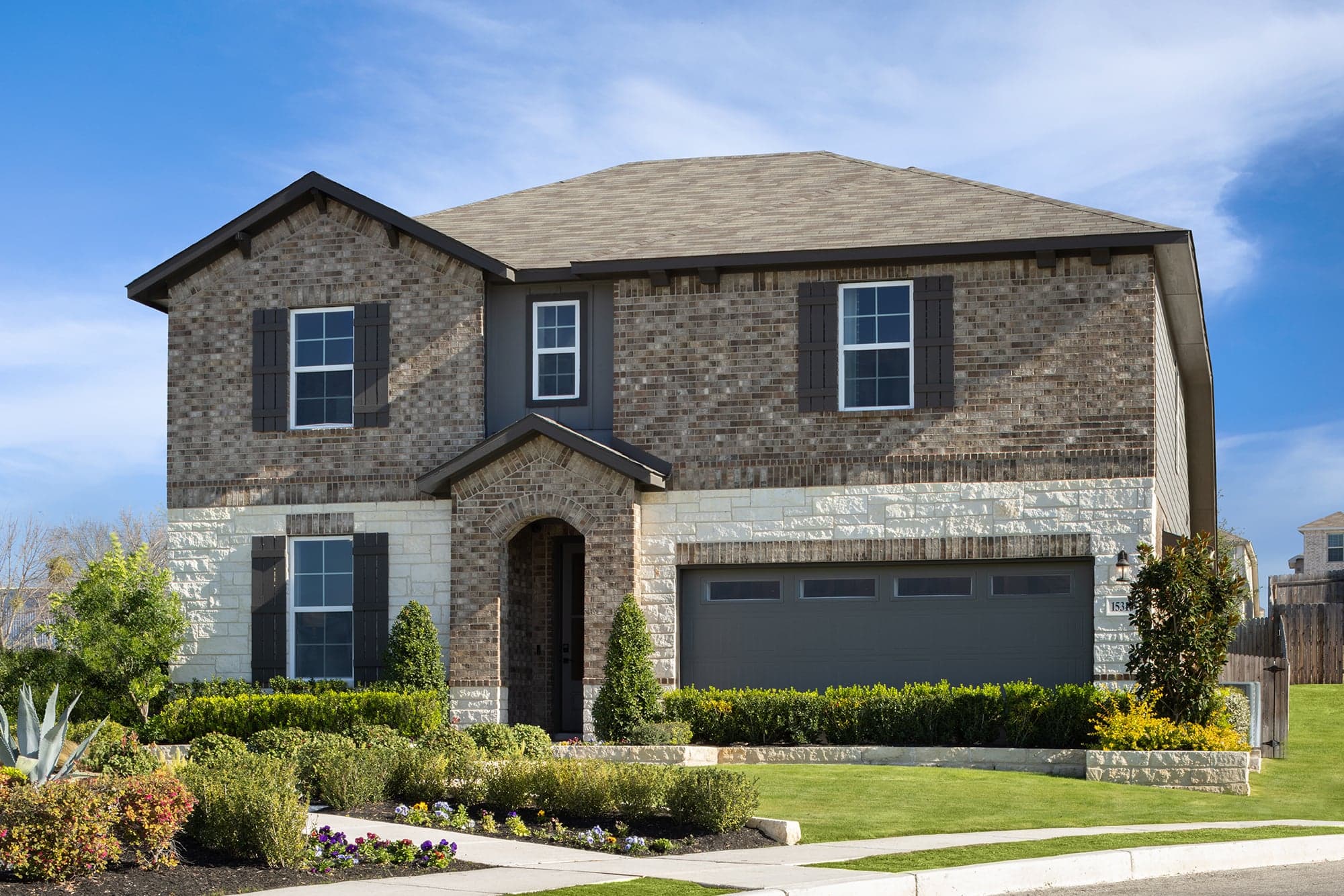 exterior with brick, tree & a 2-car garage