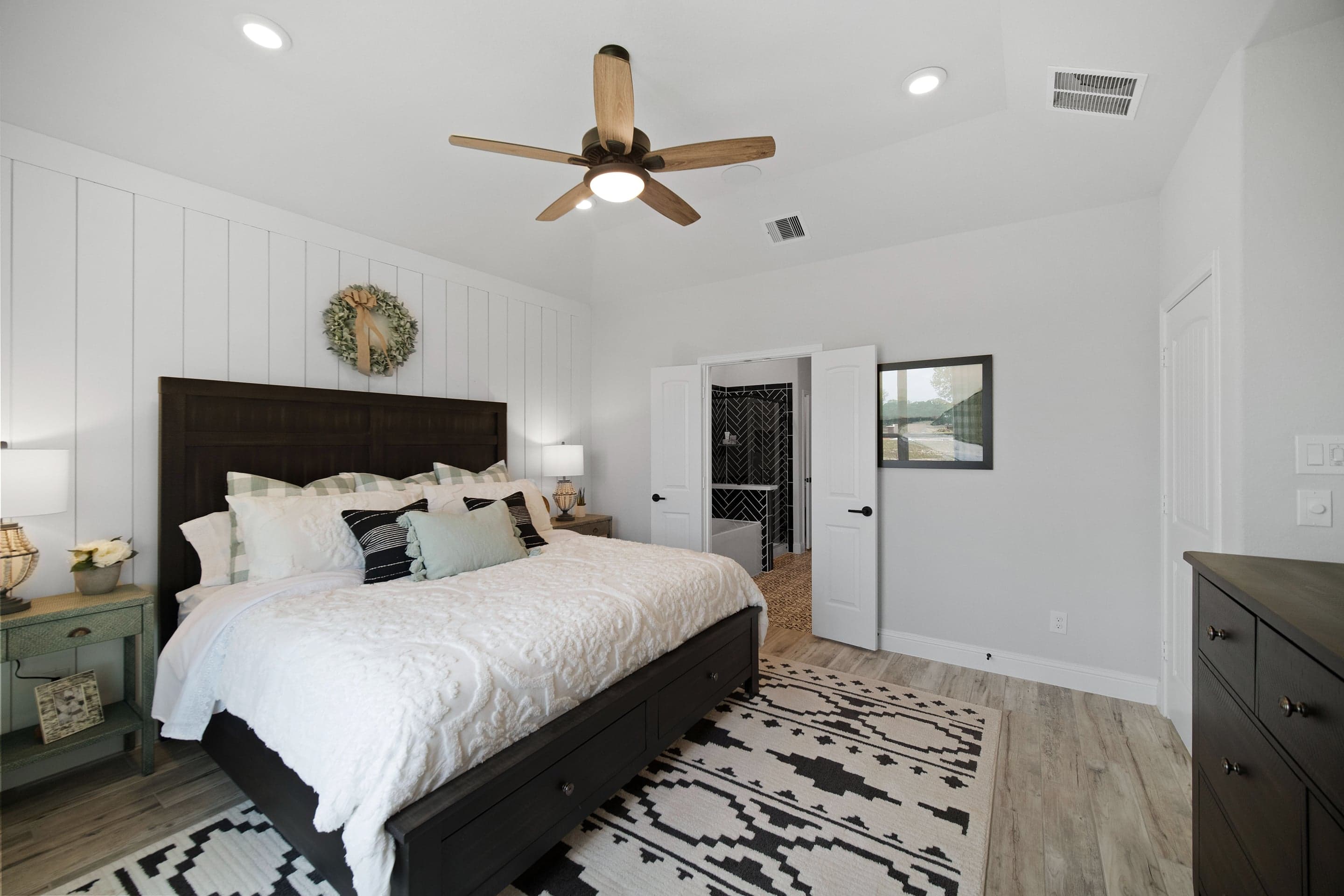 primary bedroom with accent wall and tall ceilings