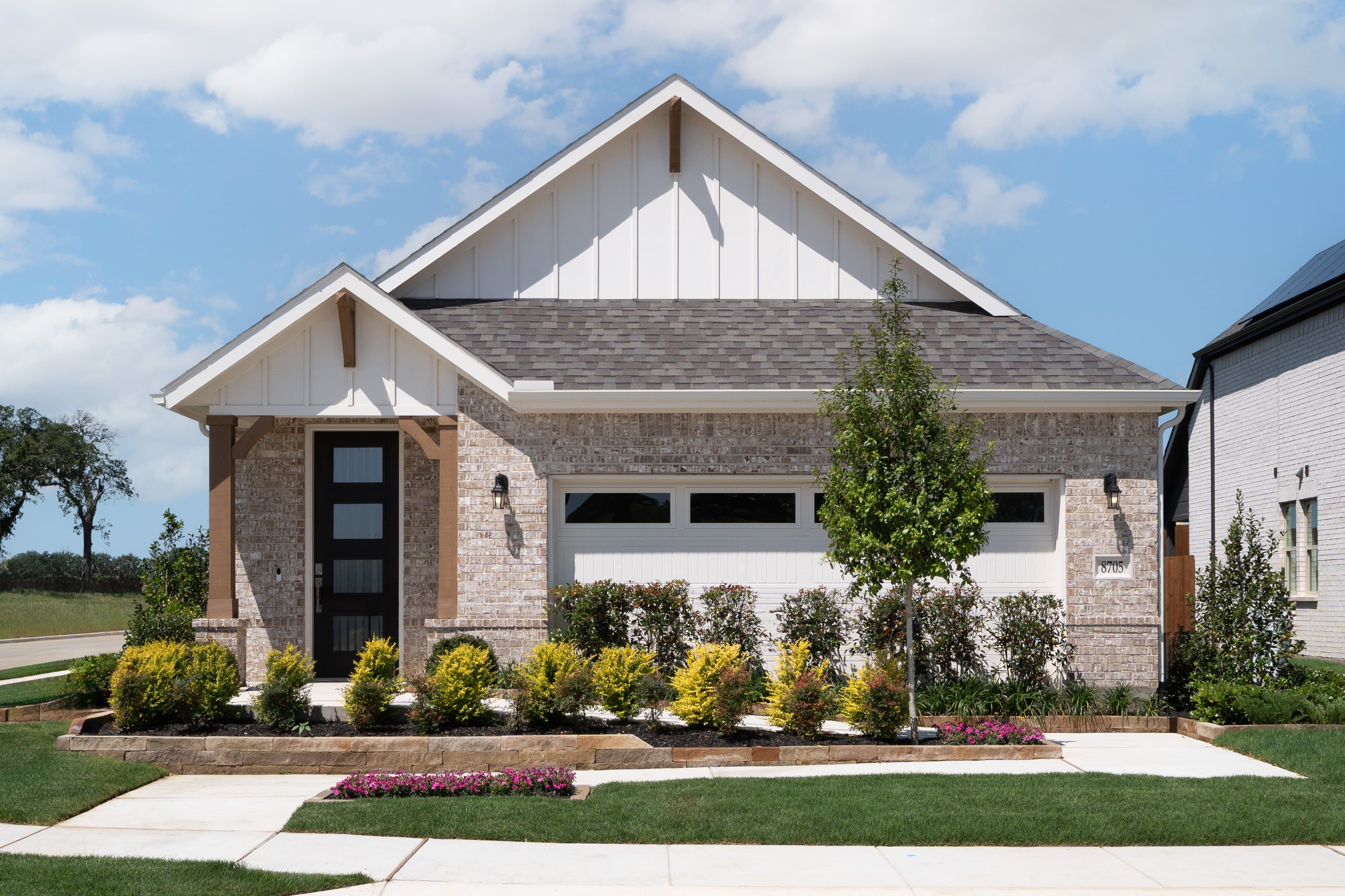 exterior of home with light brown brick and white siding