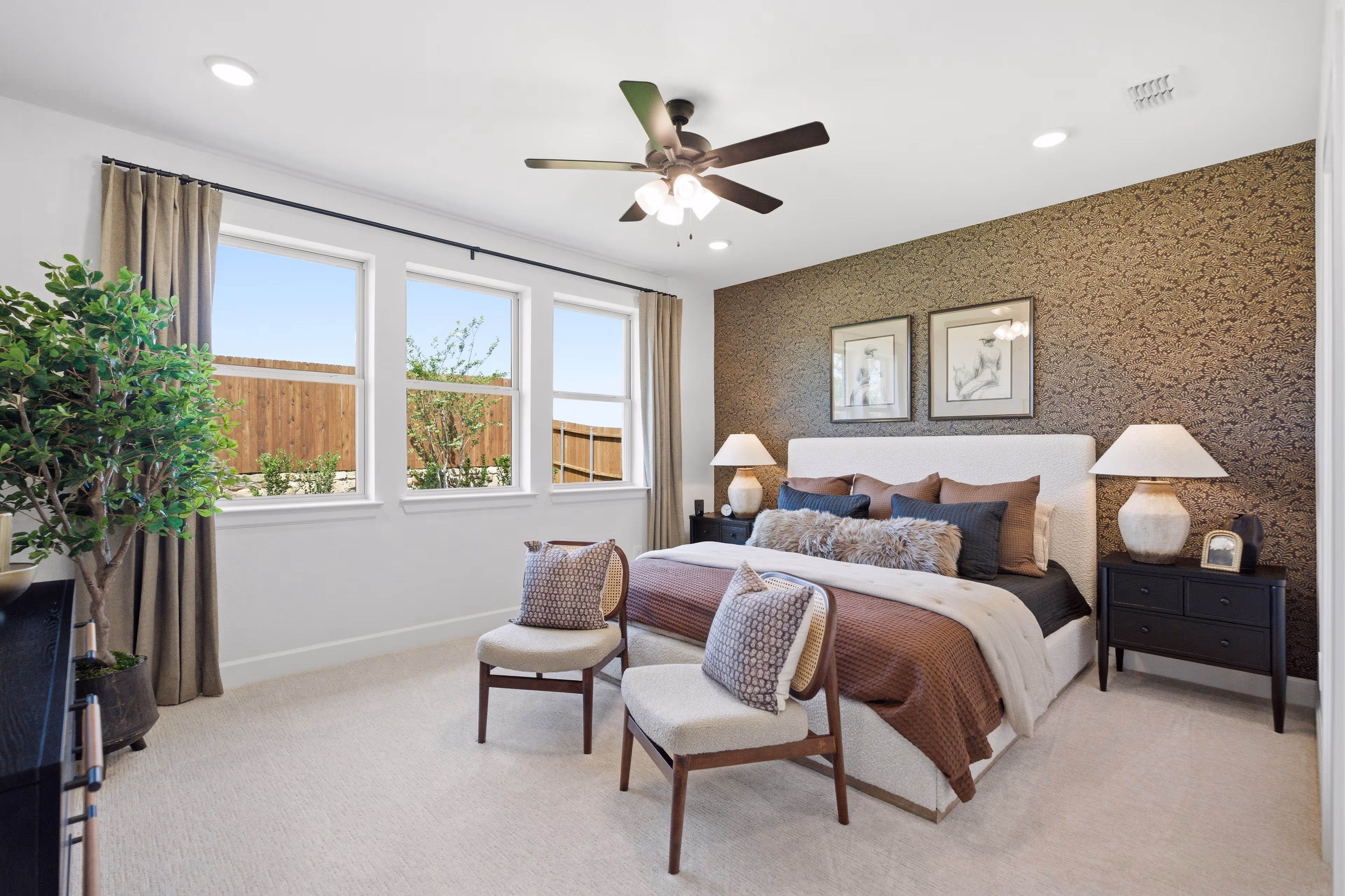 primary bedroom with accent wallpaper and carpet