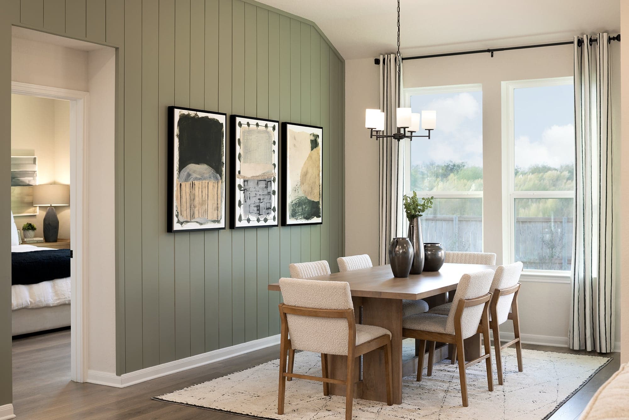 dining area with brown floors, windows and pendant lighting