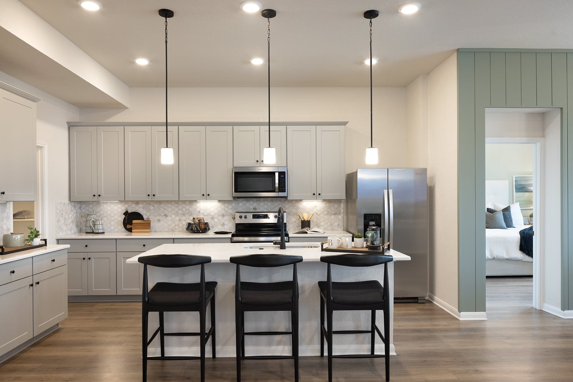 kitchen with brown floors, gray cabinets and pendant lighting