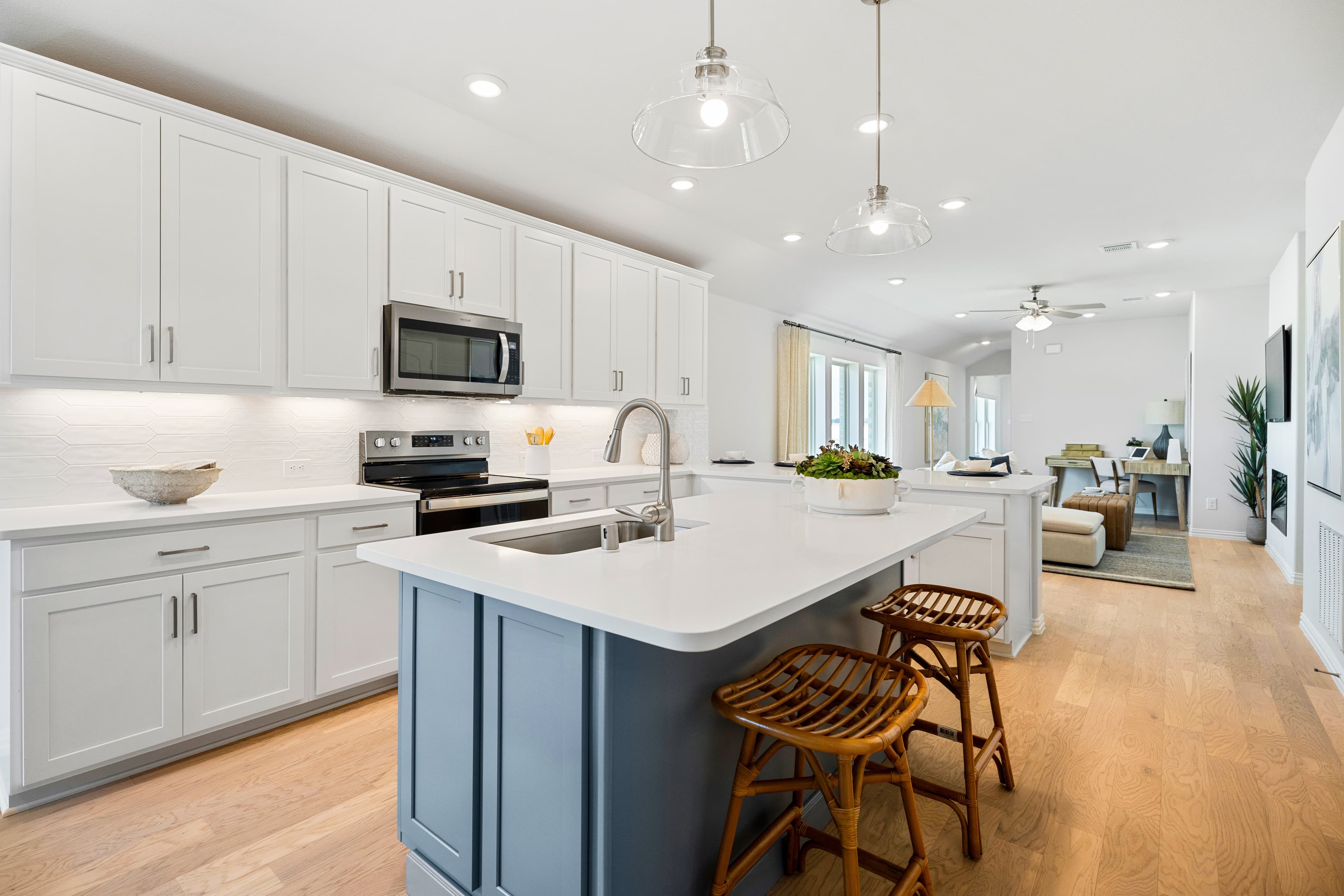 open kitchen with wood floors and white cabinets