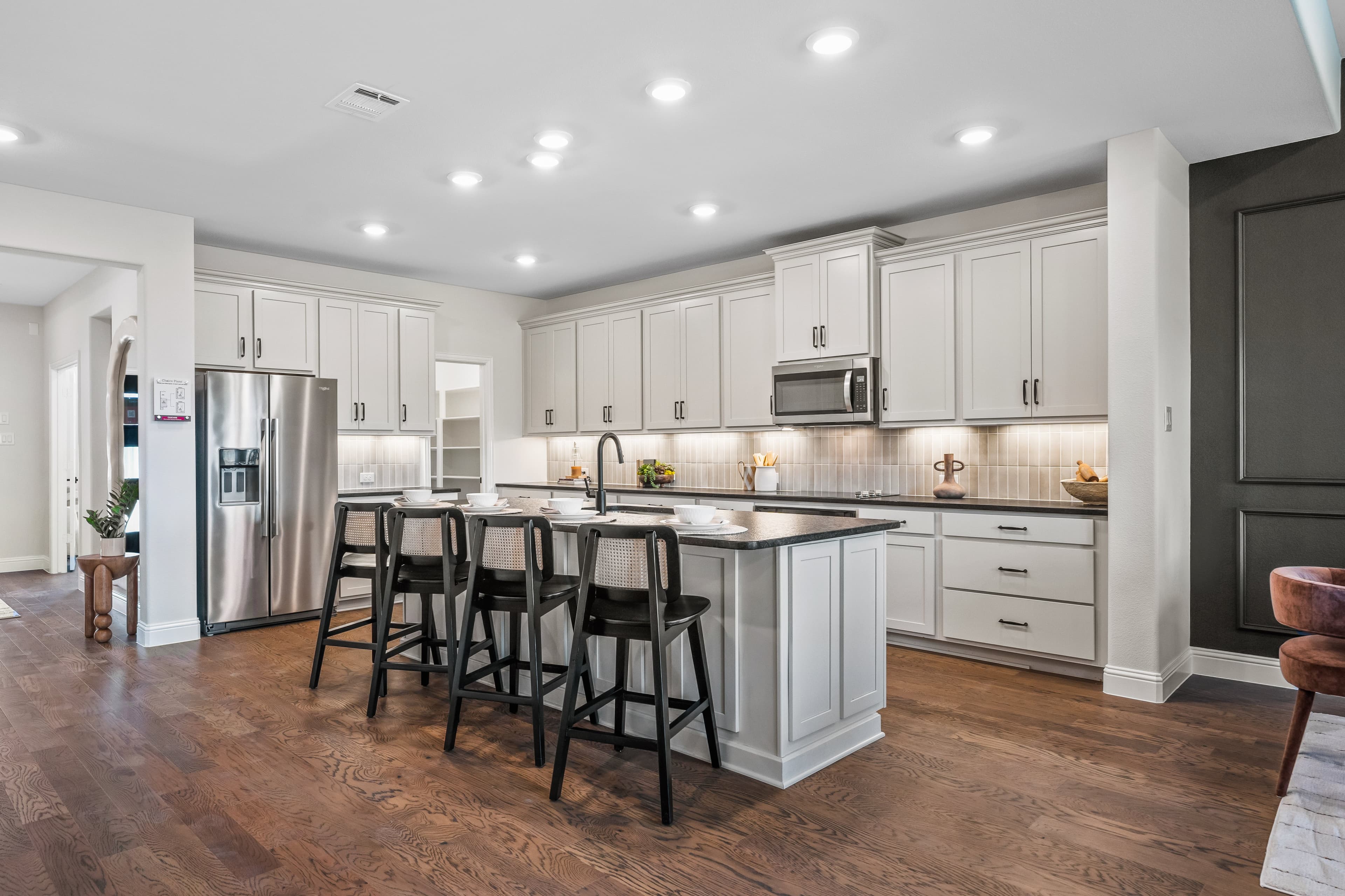 open kitchen with wood floors and white cabinets