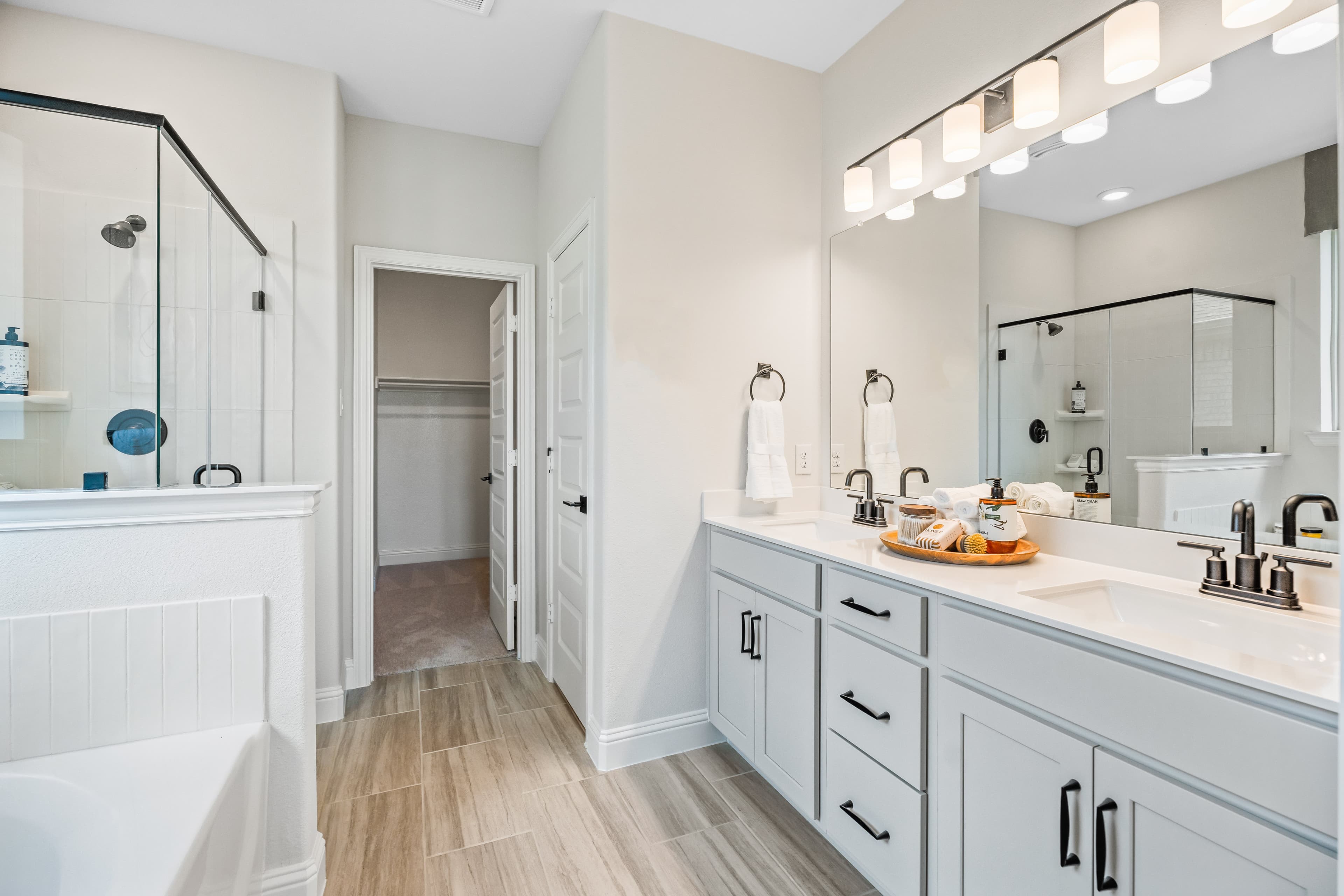primary bathroom with soaking tub, walk-in shower, and white cabinets
