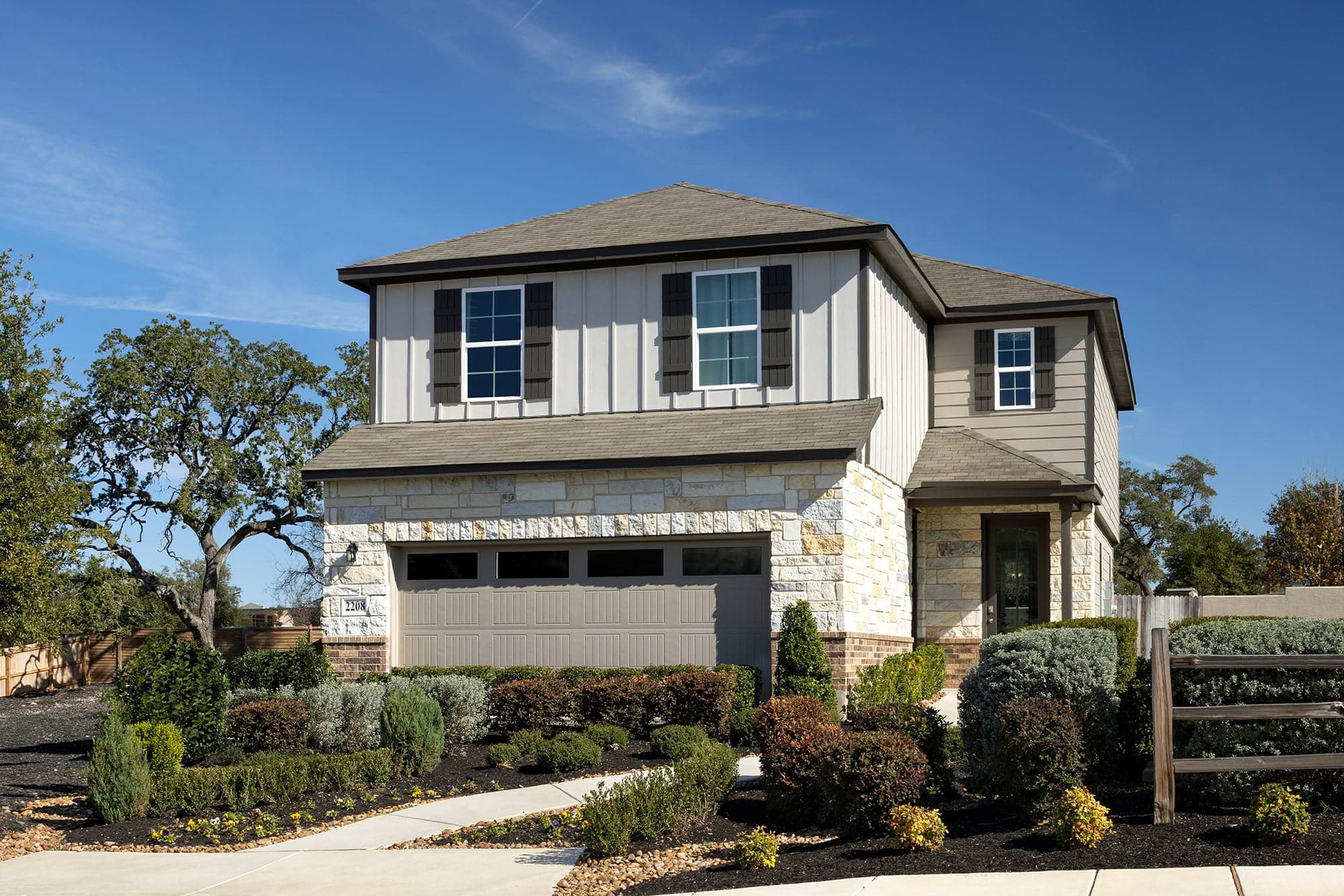 exterior with grass, garden & 2-car garage