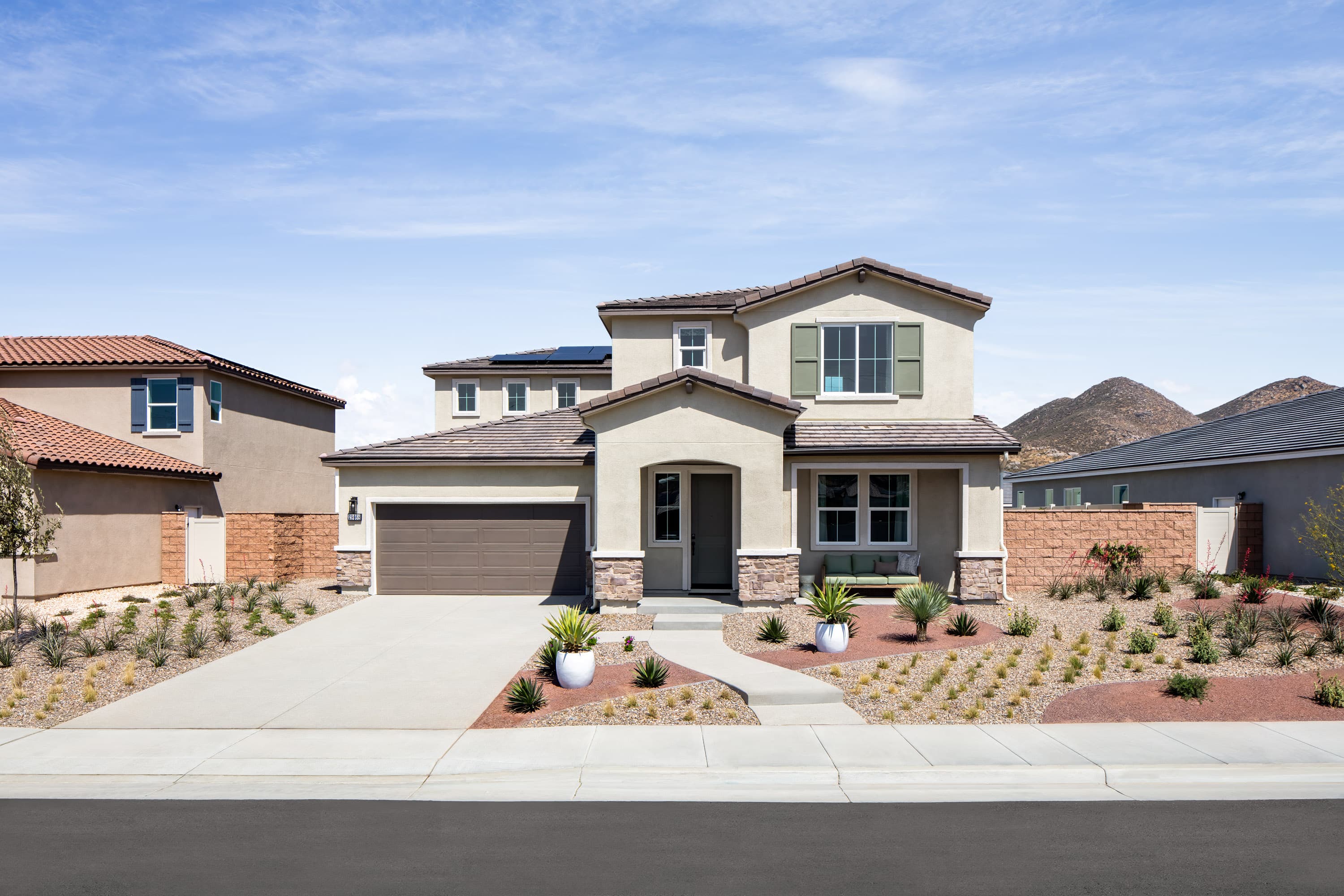 exterior of two story home with neutral paint and desert landscaping