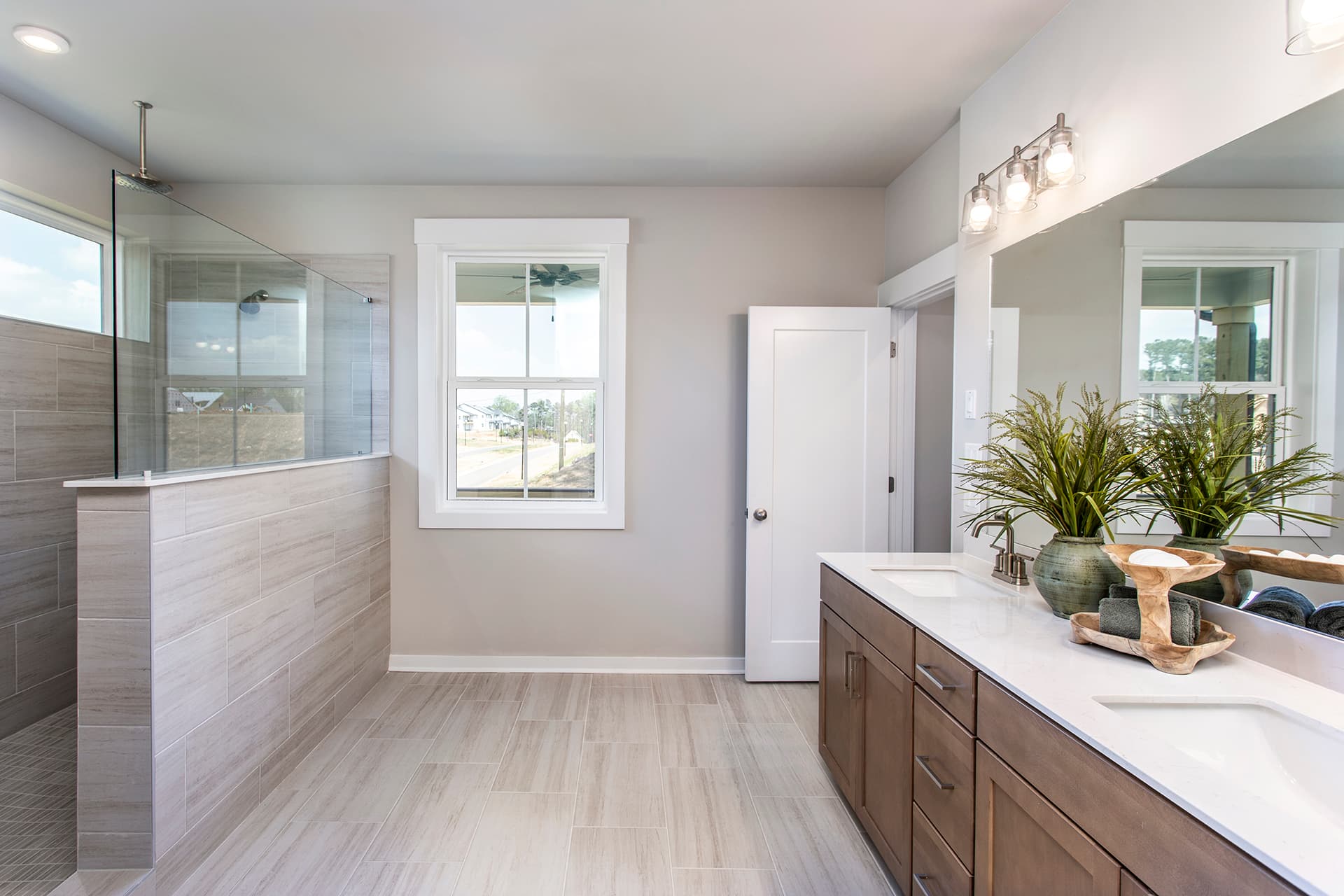 primary bathroom with large walk-in shower and wood-finish cabinets