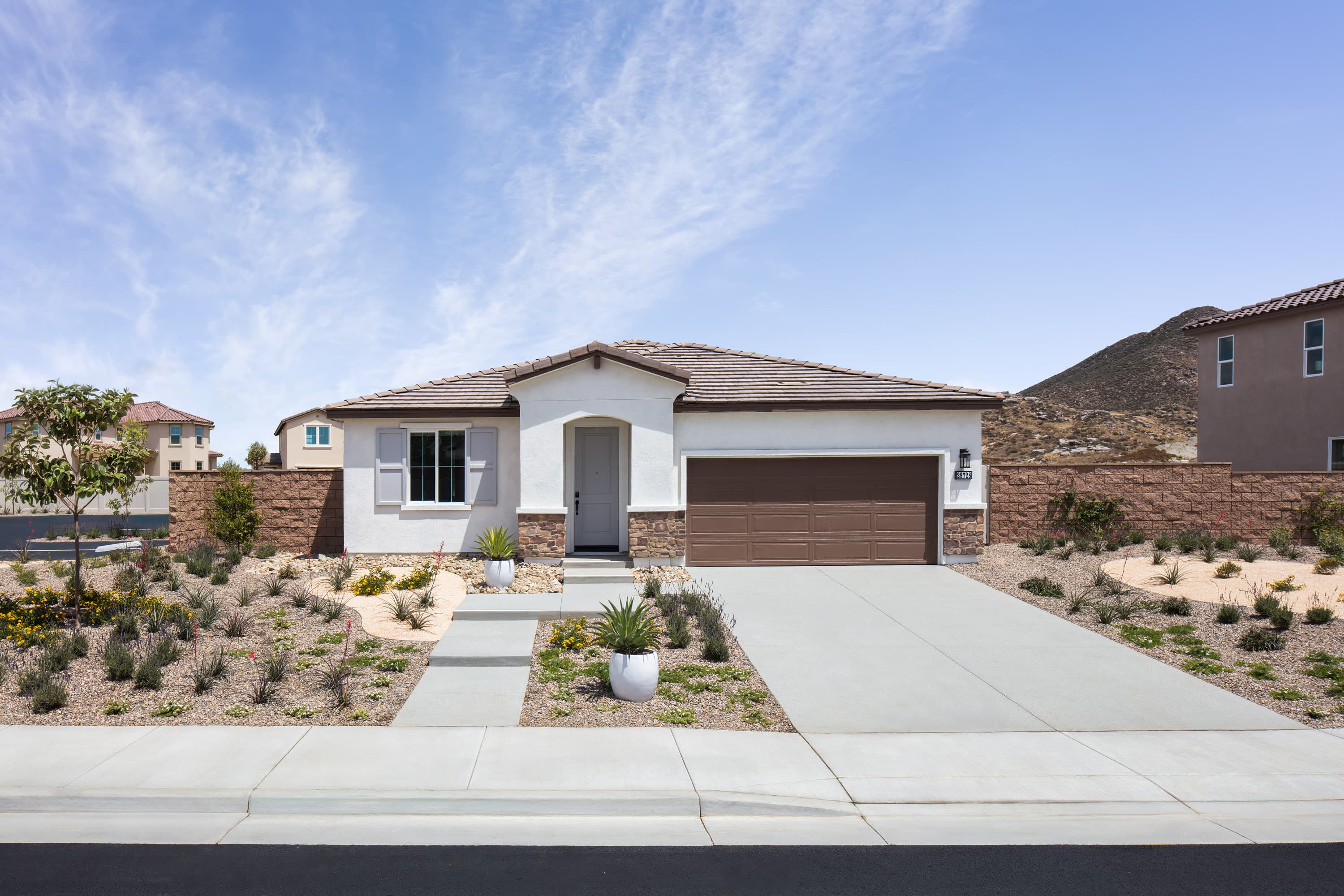 exterior of single-story home with brown garage and desert landscaping