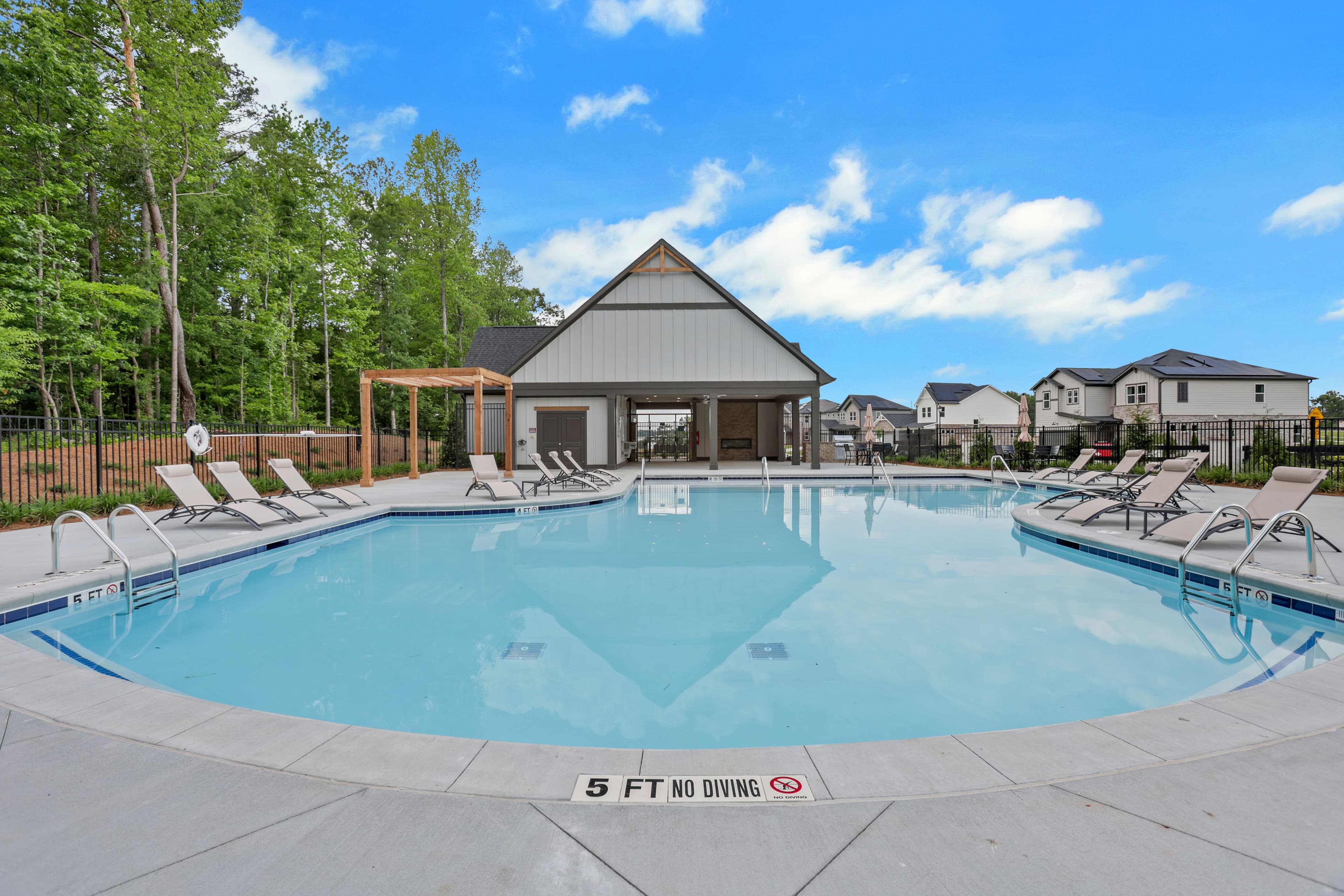 pool with clubhouse and outdoor kitchen