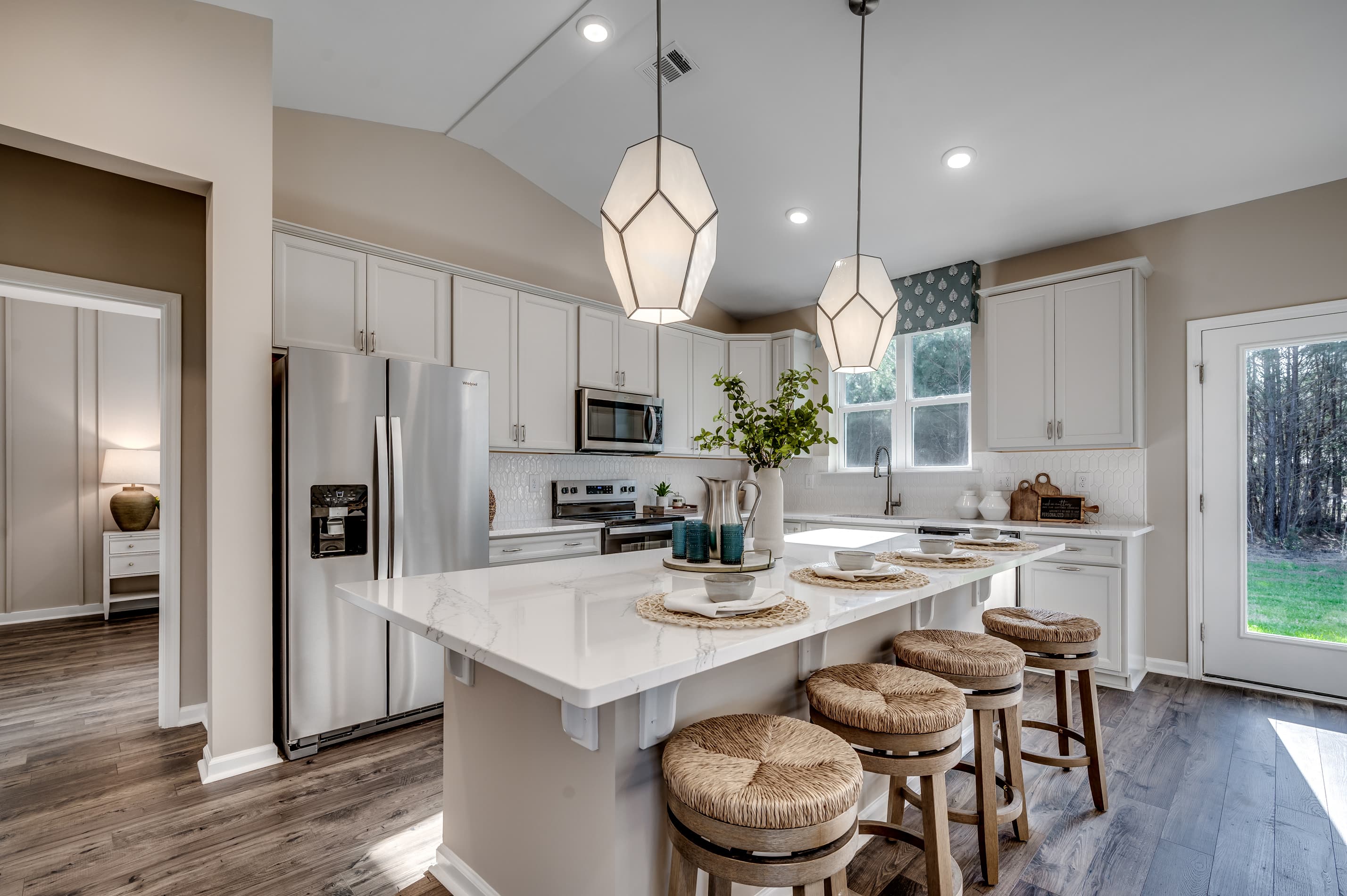 spacious island with white countertops, high ceilings and windows for natural lighting