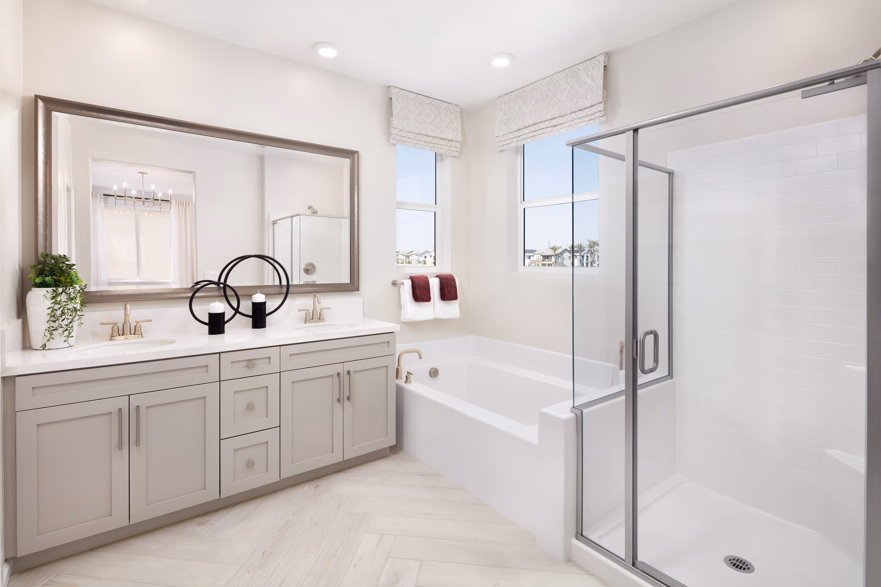 primary bathroom with large window and neutral cabinets