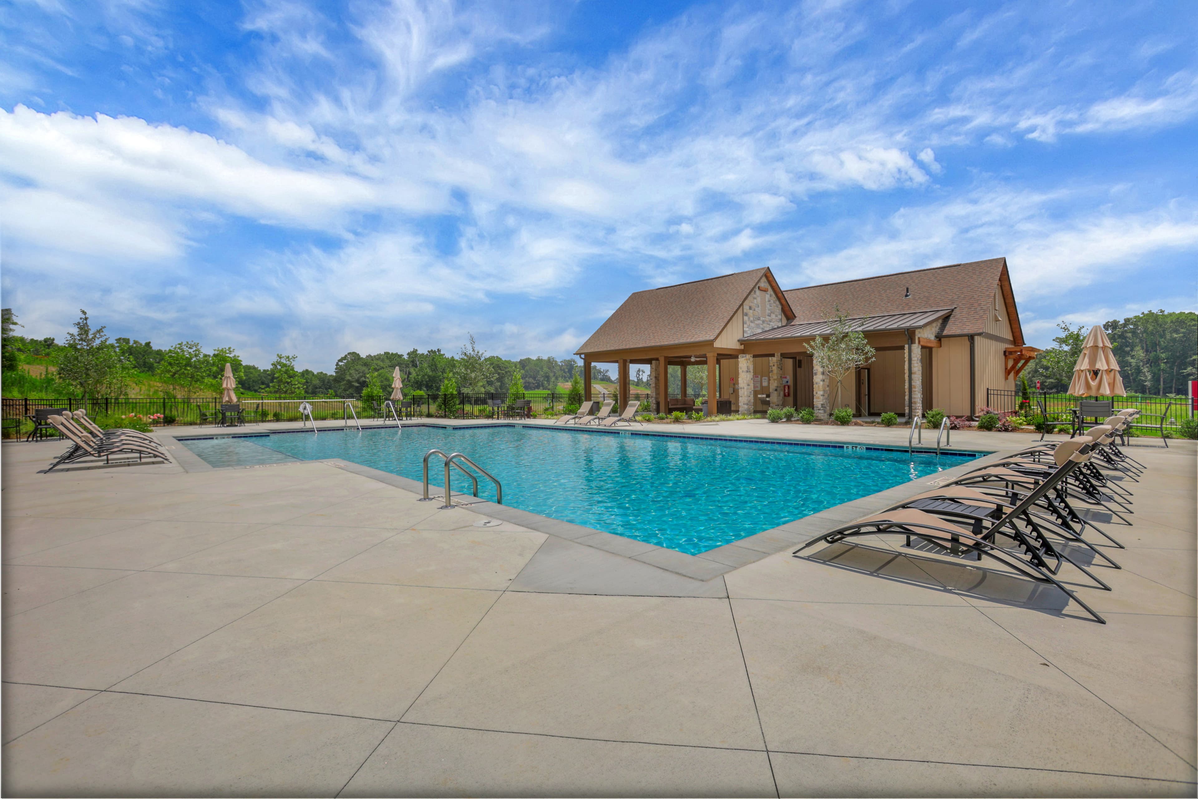 pool with clubhouse and lounge chairs
