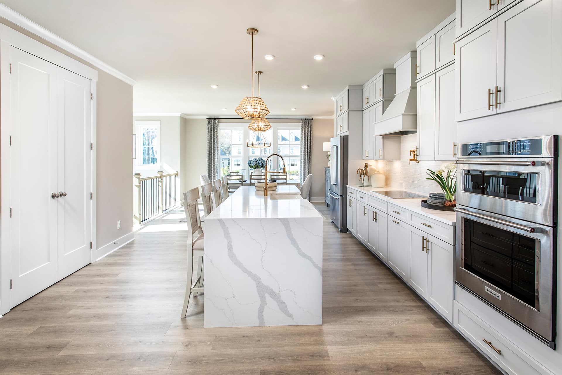 kitchen with waterfall quartz counter on the island and white cabinets
