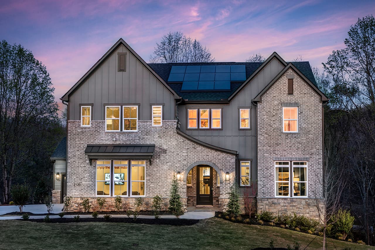 front of 2-story home with basement, dark siding, and light brick